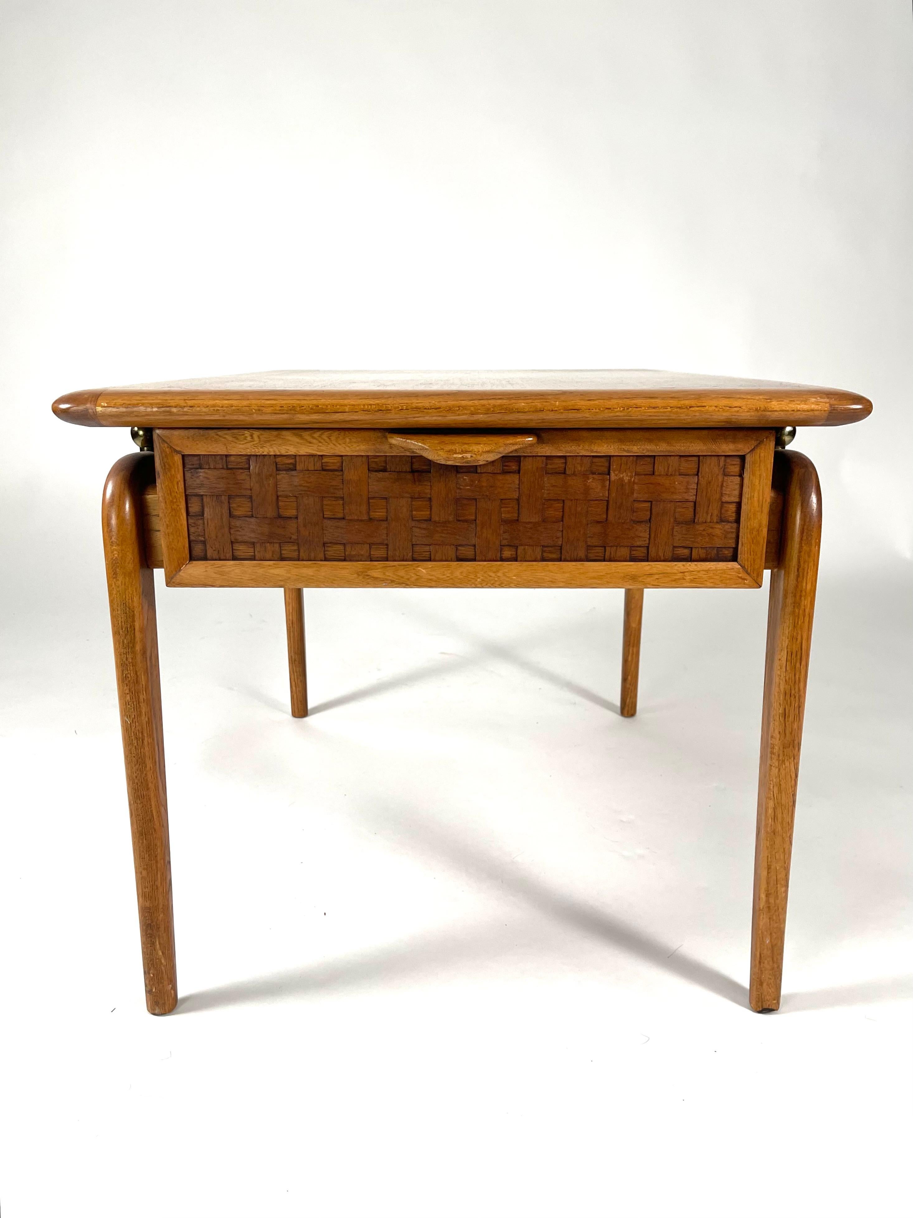 A  pair of well made, mid-century modern end tables or night tables by the Lane Furniture Company (Virginia), the rectangular tops in light mahogany and edged with oak or ash, the drawer fronts decorated with a carved basket weave pattern. The tops