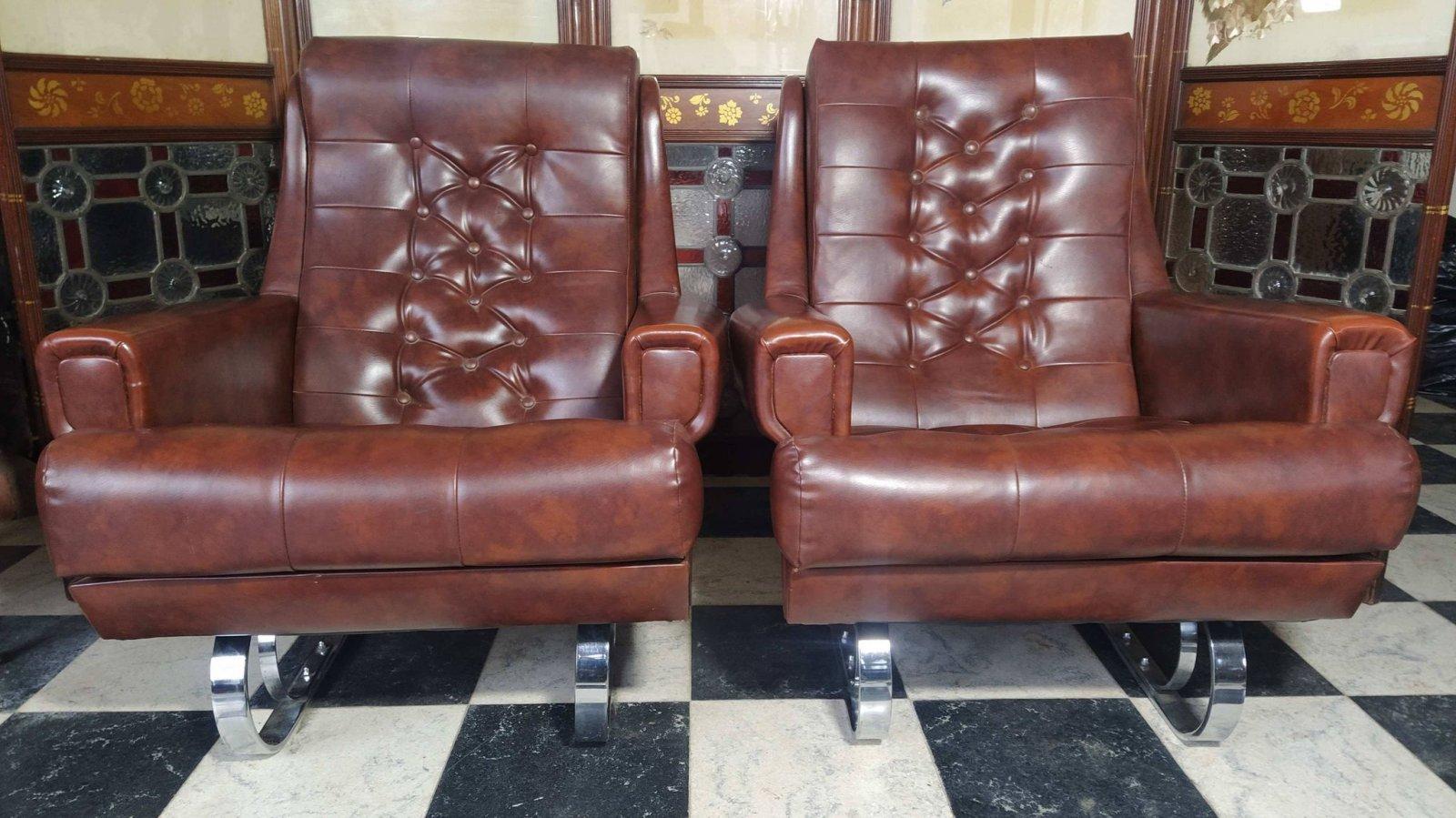 A pair of Mid-Century Modern French Cantilever armchairs with the original brown vinyl upholstery, both in really good condition. The chrome cantilever base gives it a stylish look and a gentle relaxing movement when one sits in it or rocks it.