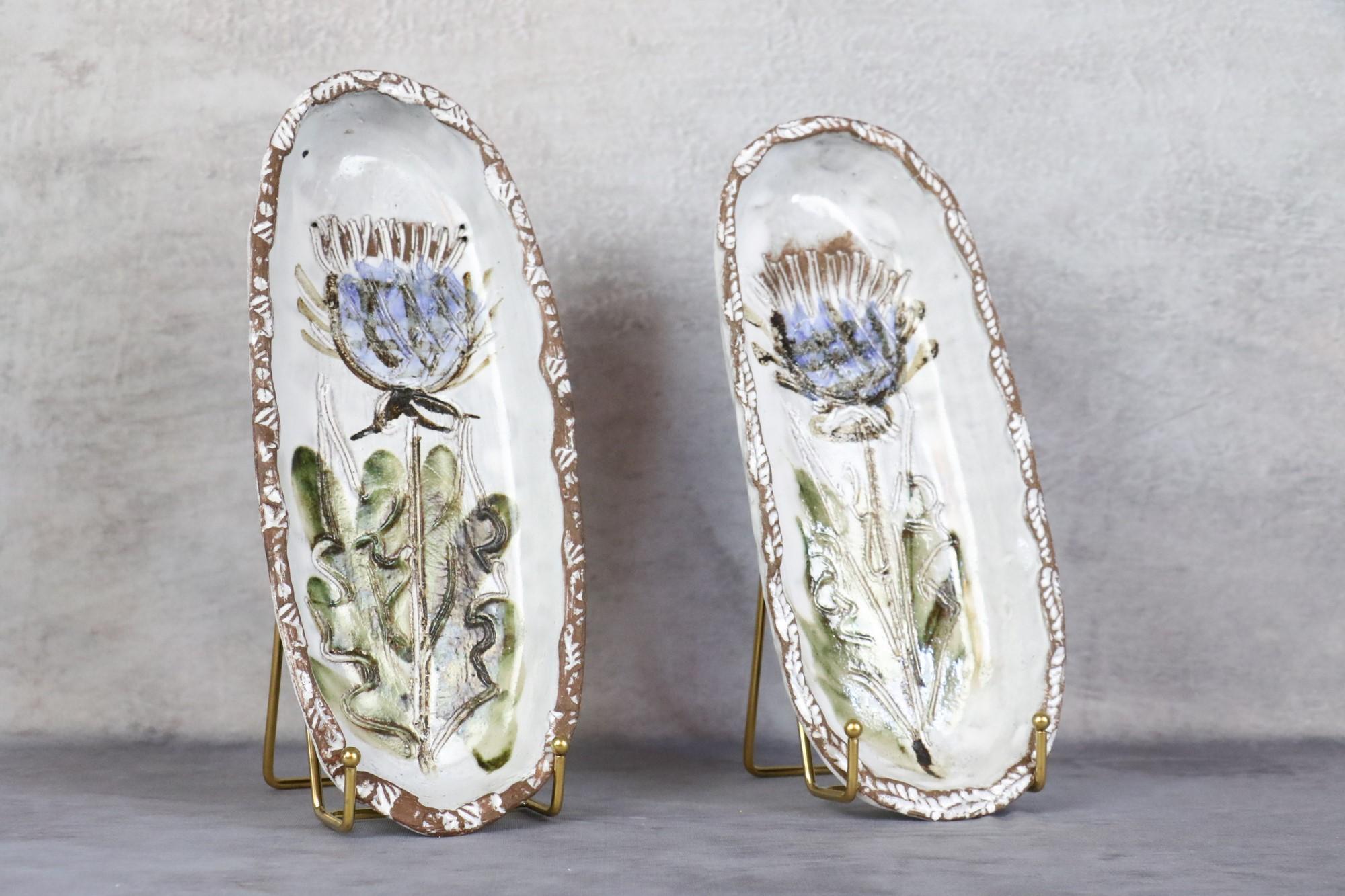 Pair of Mid-Century Modern French ceramic decorative trays Albert Thiry, 1960s

Very nice set of two decorative ceramic trays decorated with blue flowers. The chalk white enamel is of very good quality. It brings out the motifs engraved by the