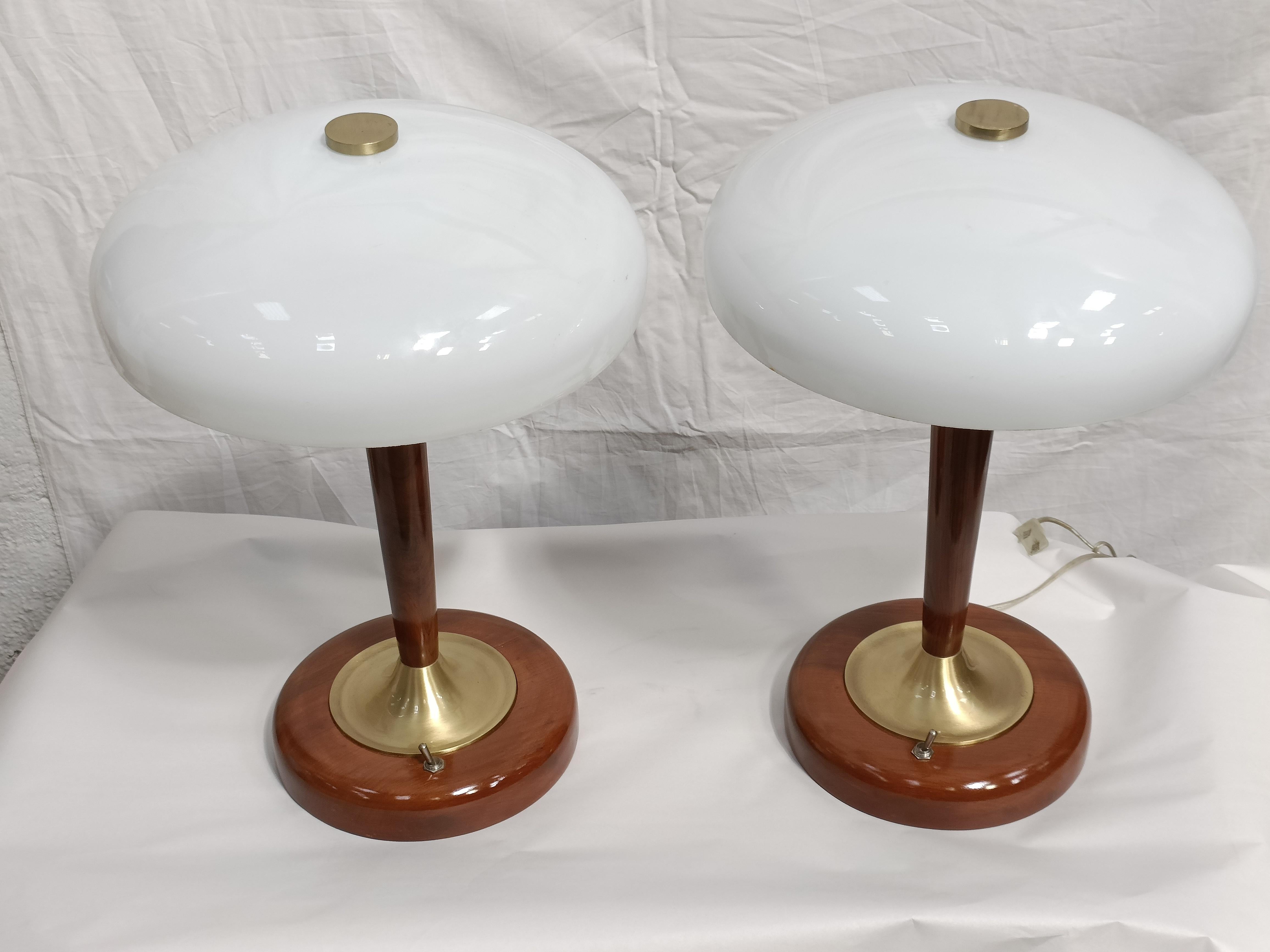 A pair of Mid-Century Modern table lamps with teak and brass stem and base and round, frosted dome shades.  Takes three standard base light bulbs, electrified for American use.  Base itself has an 8.5