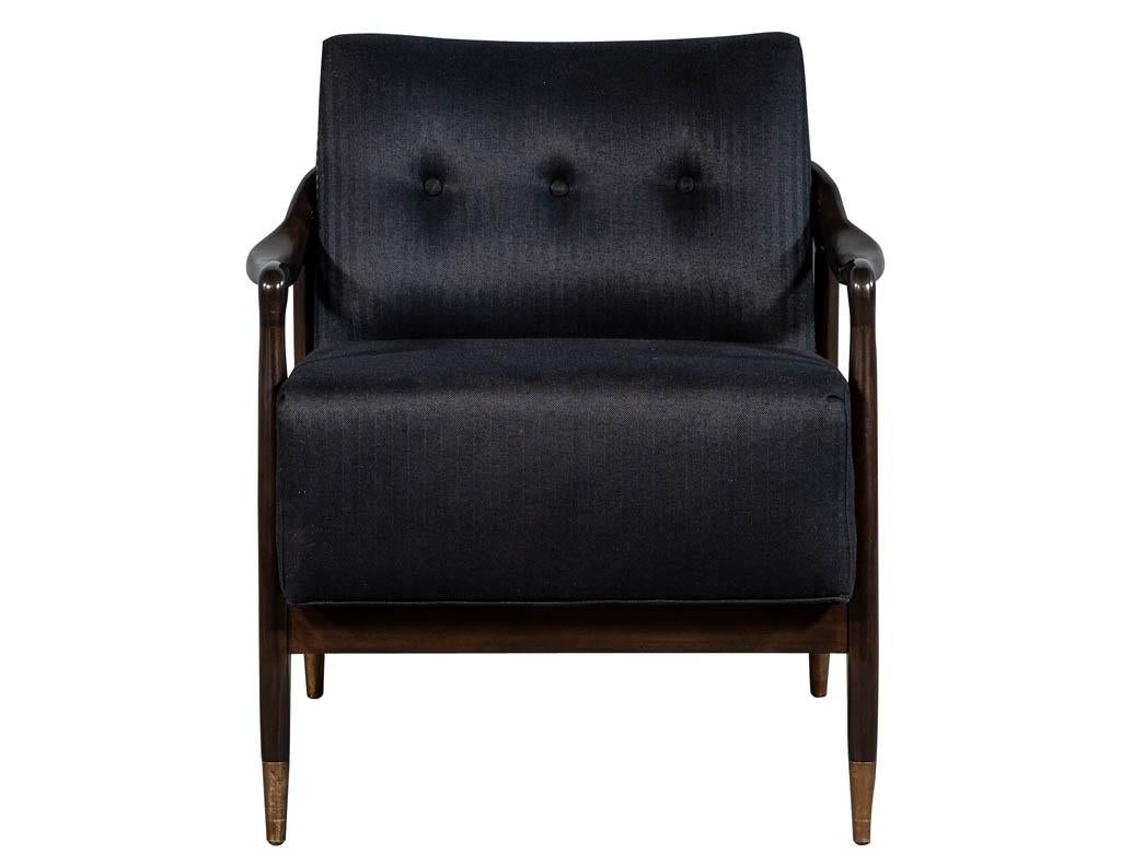 Pair of sleek Mid-Century Modern club chairs, with a beautifully sculpted walnut show wood frame accented with brass caps and head to head hand applied upholstery tacks upholstered in a rich pinstripe fabric.

Price includes complimentary