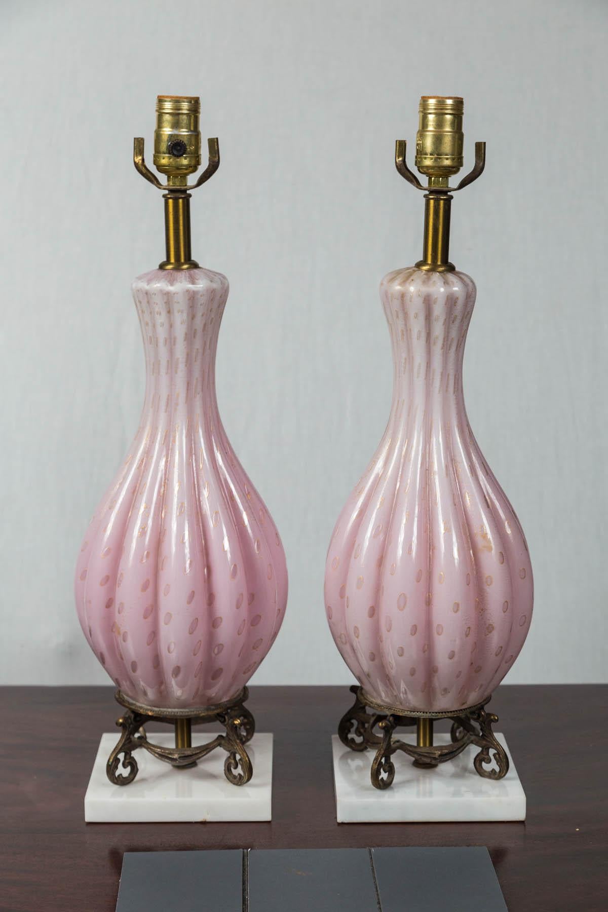 Pale pink glass with deeper pink cuts. Ribbed bulbous body. Raised on brass 4 legged base.
Glass with base measure 16 inches, not including lamp fittings
base measures 5.5 x 5.5.
