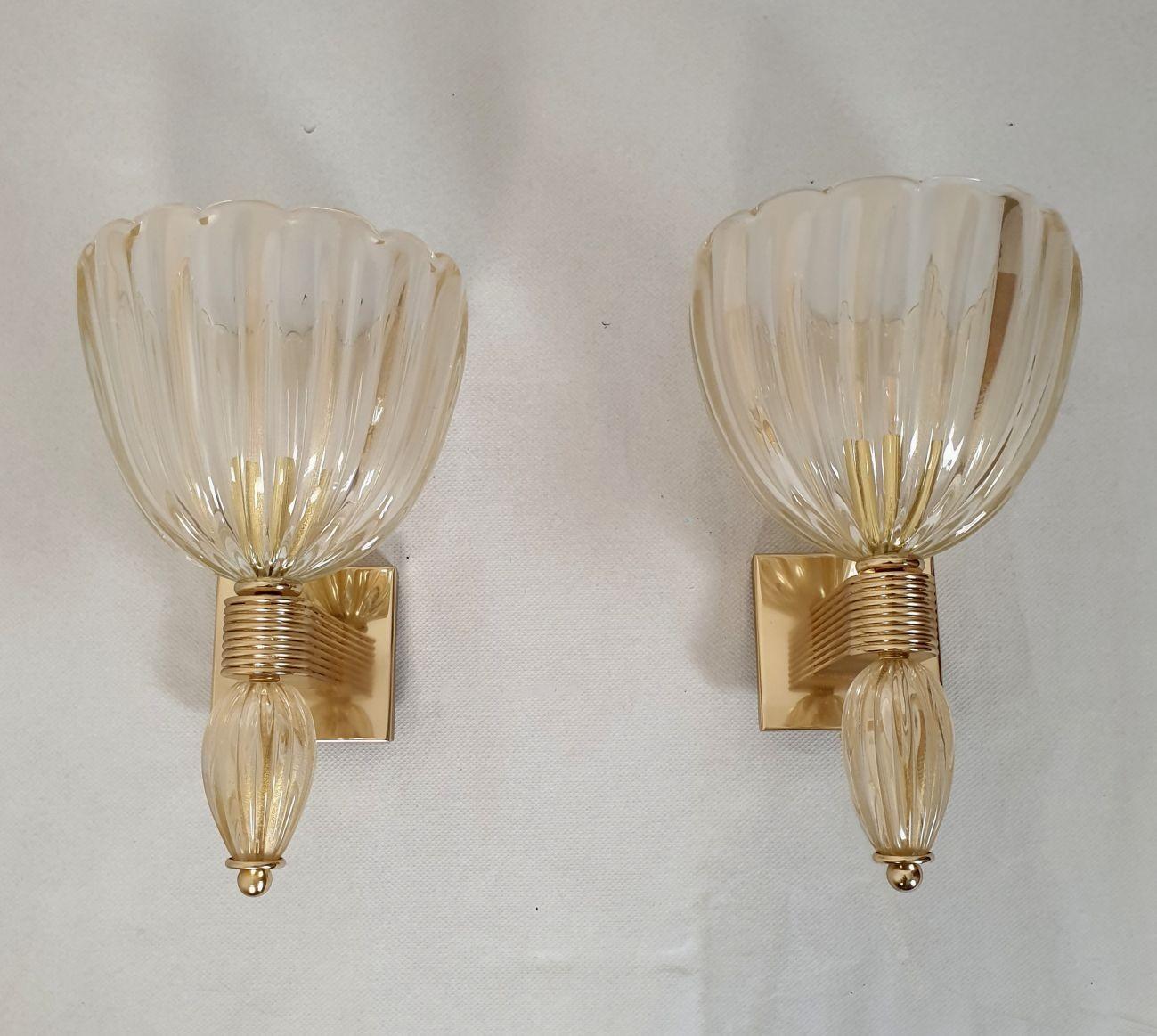 Pair of large Murano glass Mid-Century Modern sconces, attributed to Barovier & Toso, Italy 1980s.
Set of four sconces or two pairs available.
Sold and priced by pair.
The neoclassical sconces are made of a clear Murano glass, with real 24 carats