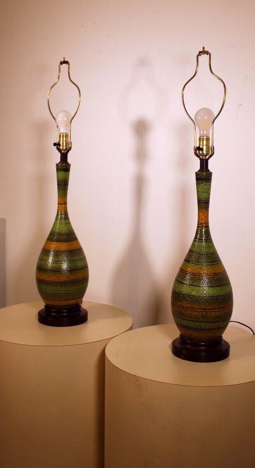 A lovely pair of green Mid-Century Modern striped ceramic lamps with wood base. In very good condition. Dimensions: 7.5
