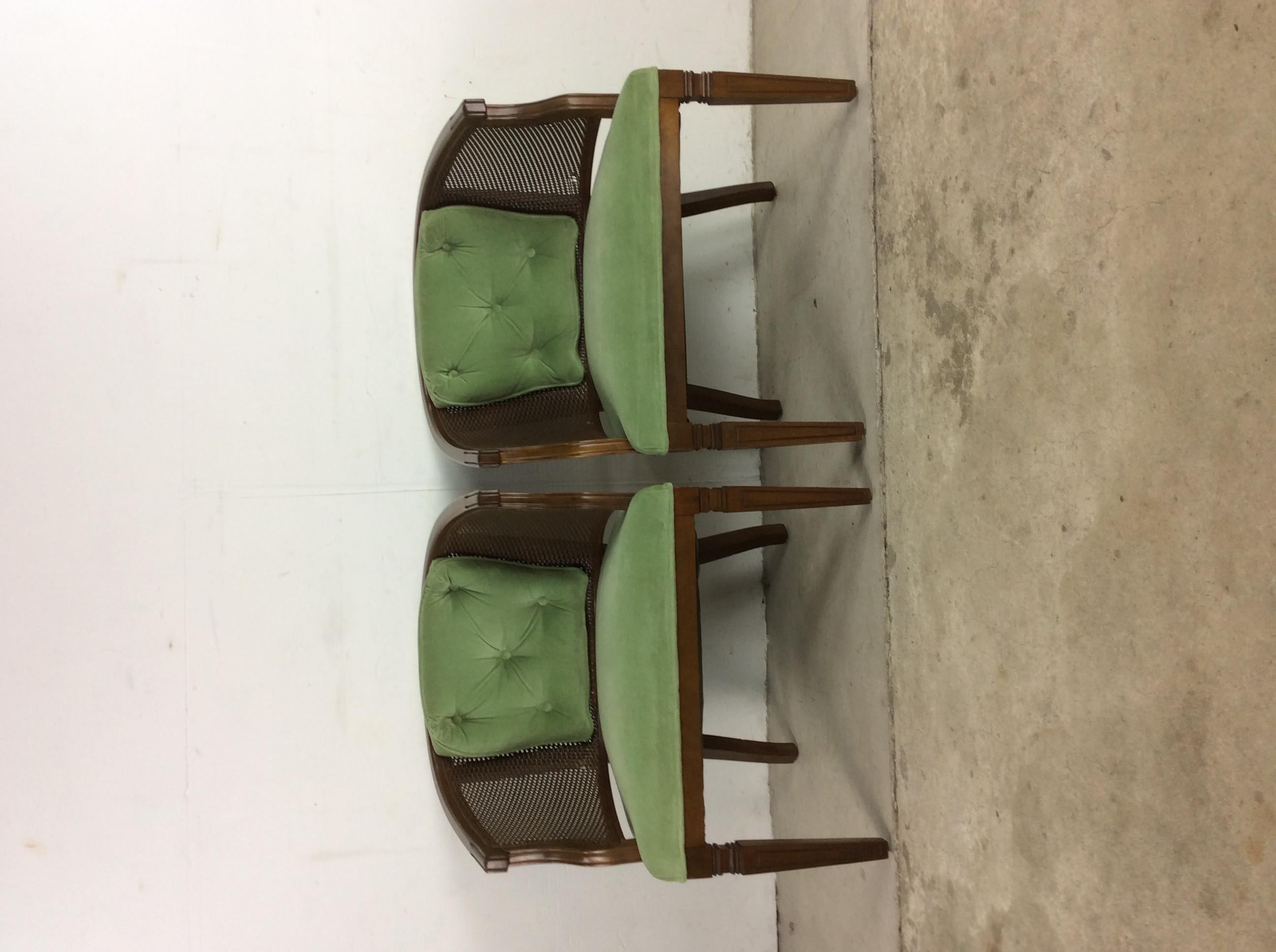 This pair of vintage accent chairs features hardwood construction, original walnut finish, cane accenting on the back and sides, green upholstery with tufted seat back, and tall tapered legs.
Dimensions: 25 W 20 D 29.5 H 16.5 SH.
 