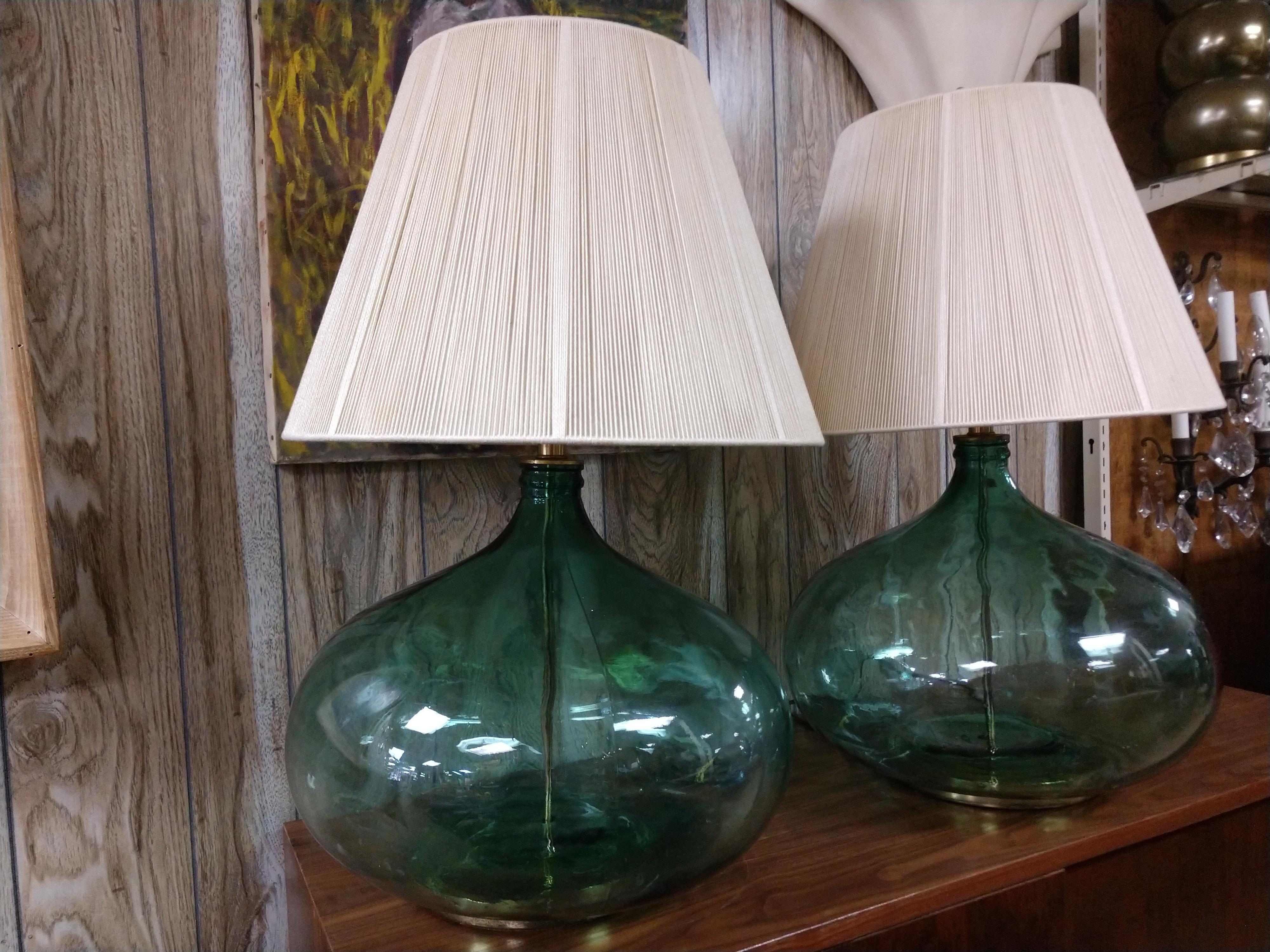 Fabulous pair of large green translucent squat bottle shaped Italian table lamps, circa 1950. Large in diameter, 18in. with a height of 20 in. to the top of the socket, 30 top of finial.
Both marked Made in Italy. Displayed with Hilo- Steiner