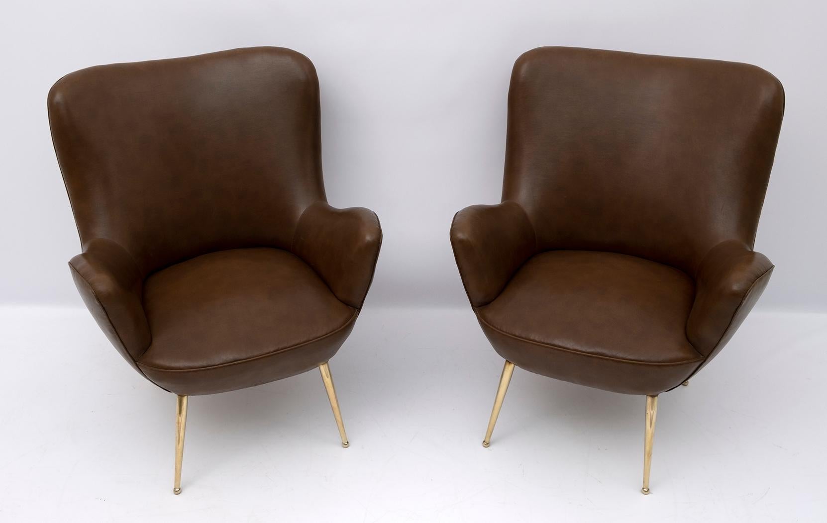 Pair of armchairs covered in eco-leather and brass feet, 1950s Italian design.
The armchairs have original upholstery, as shown in the photos in good condition but with small signs of aging.

