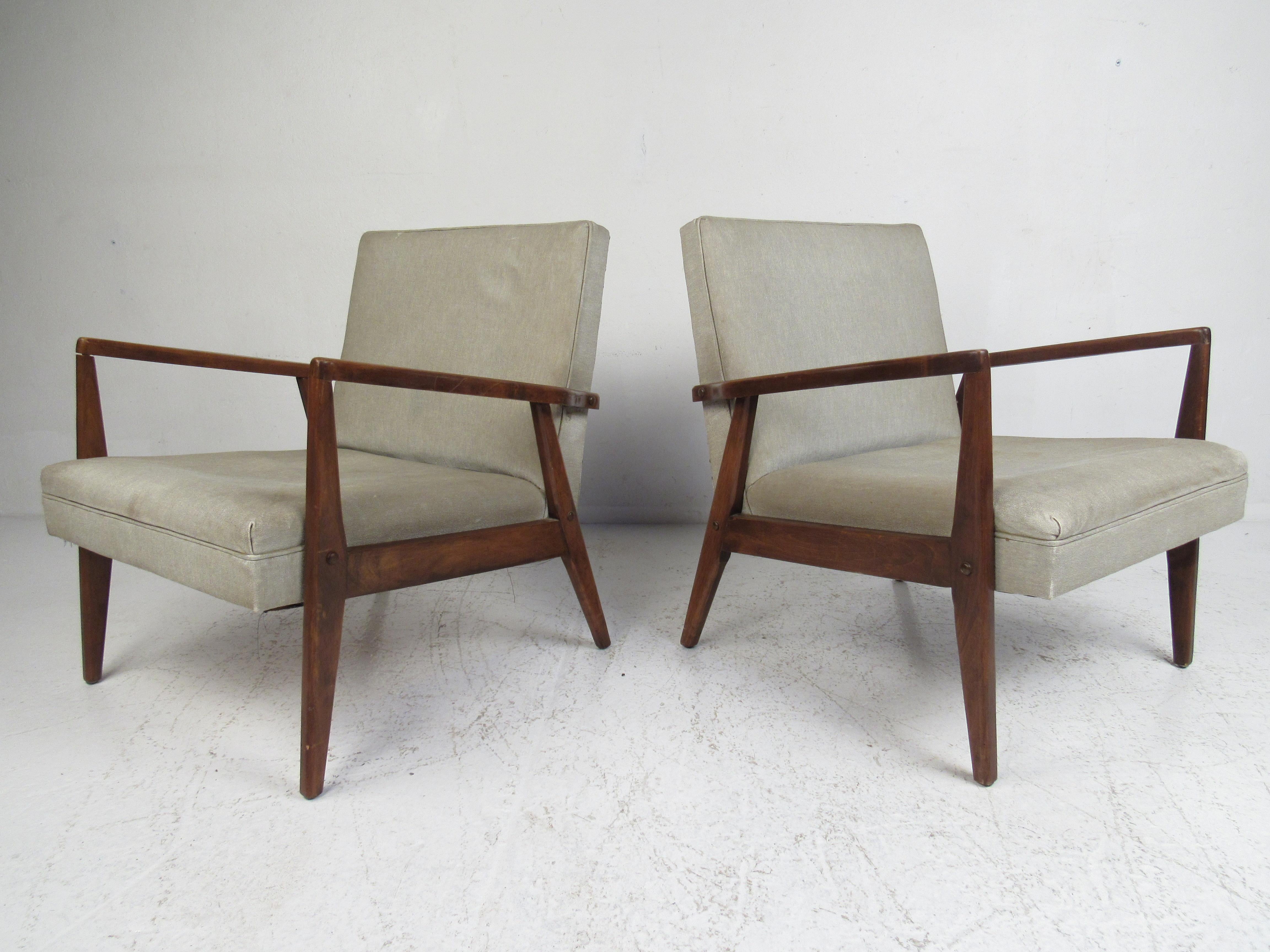 A stunning pair of vintage modern Italian lounge chairs with sculpted armrests and angled back legs. The sleek design ensures maximum comfort without sacrificing style. Please confirm item location (NY or NJ).