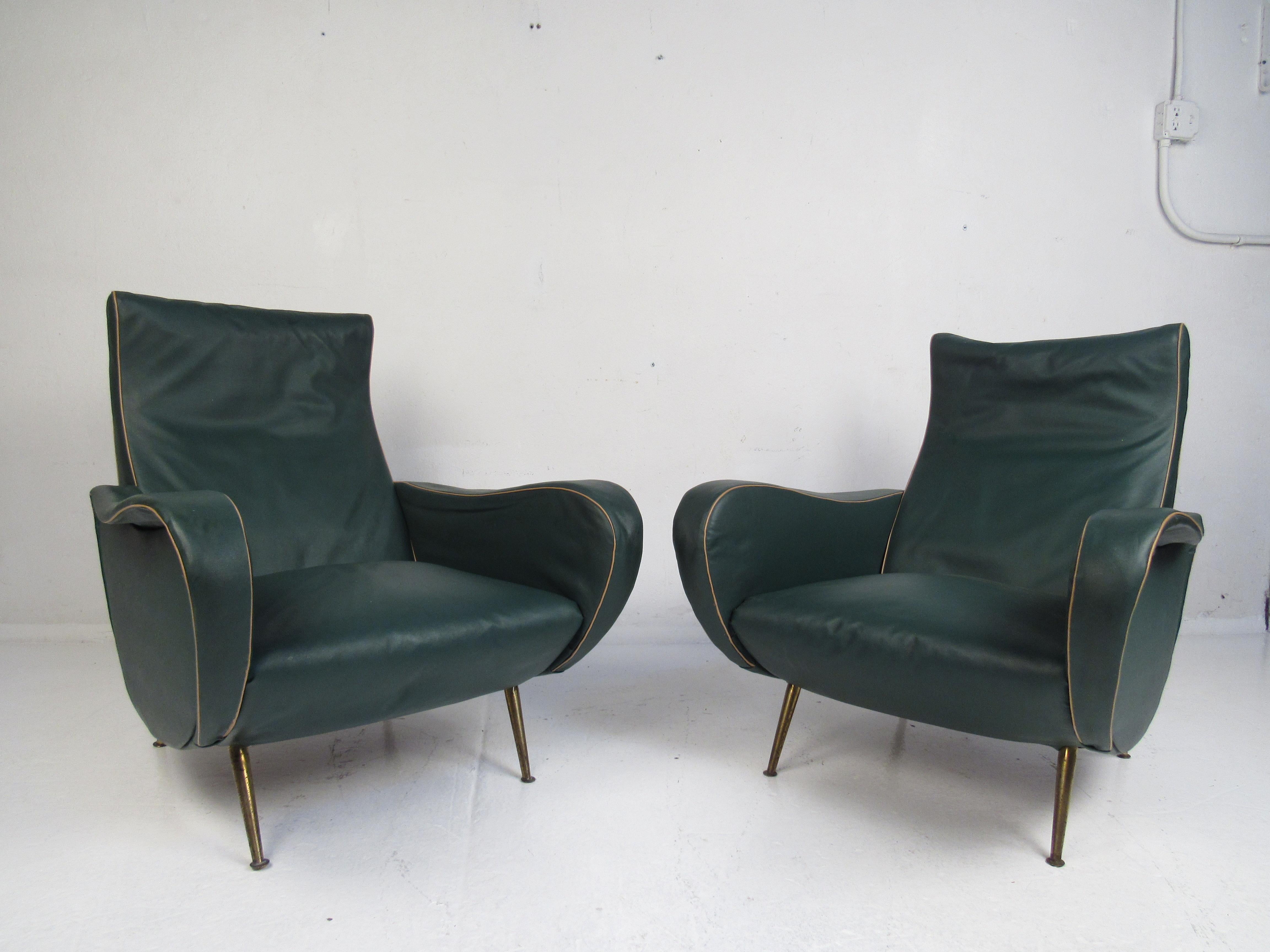 This beautiful pair of vintage modern armchairs boast thick padded seats, unusual armrests, and splayed brass legs. This sleek and comfortable pair of chairs make the perfect addition to any seating arrangement. In the style of Marco Zanuso. Please