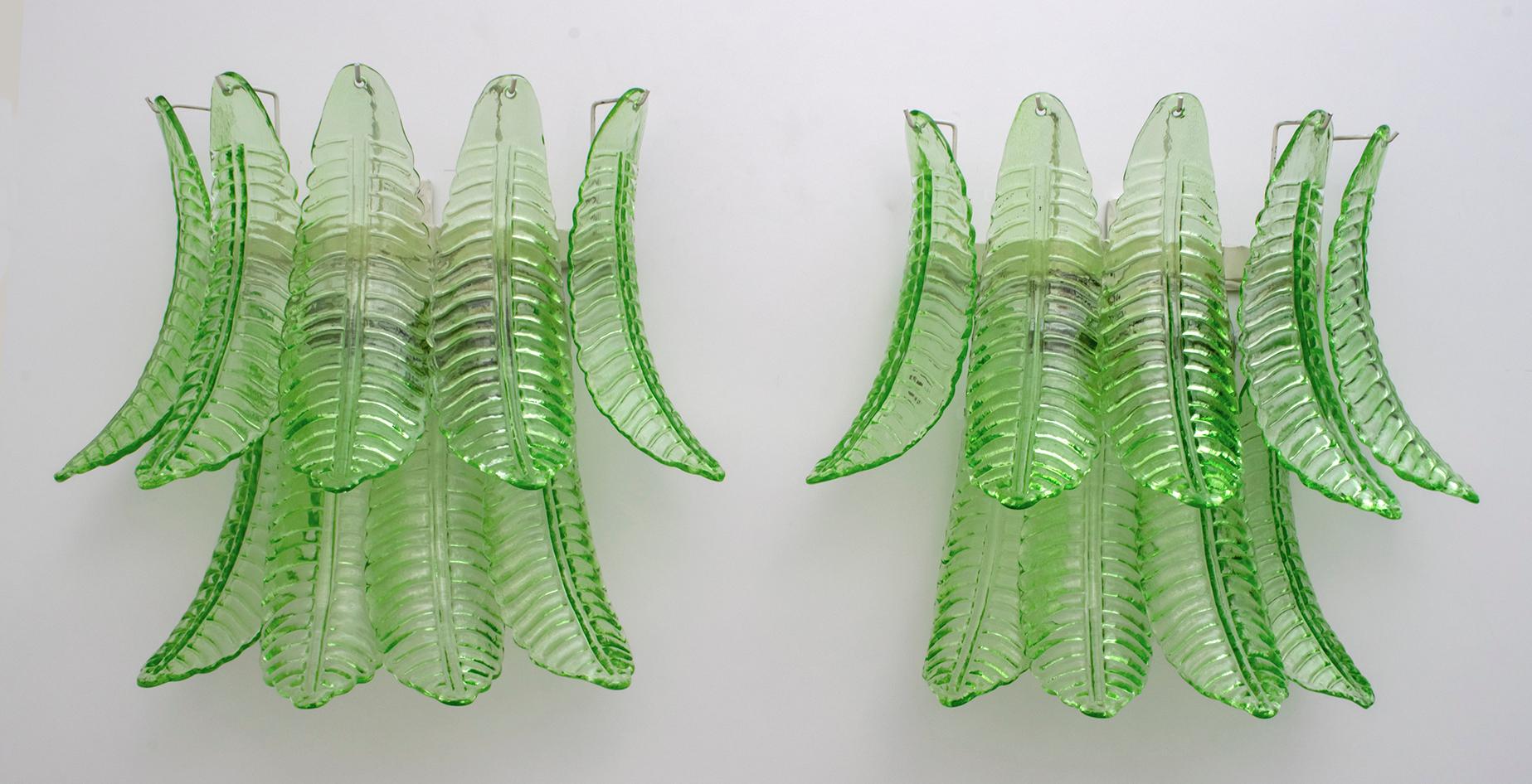 Pair of green Murano blown glass sconces, metal support, two bulbs.
These wall lamps are also sculptures that reproduce the leaves of a palm tree.