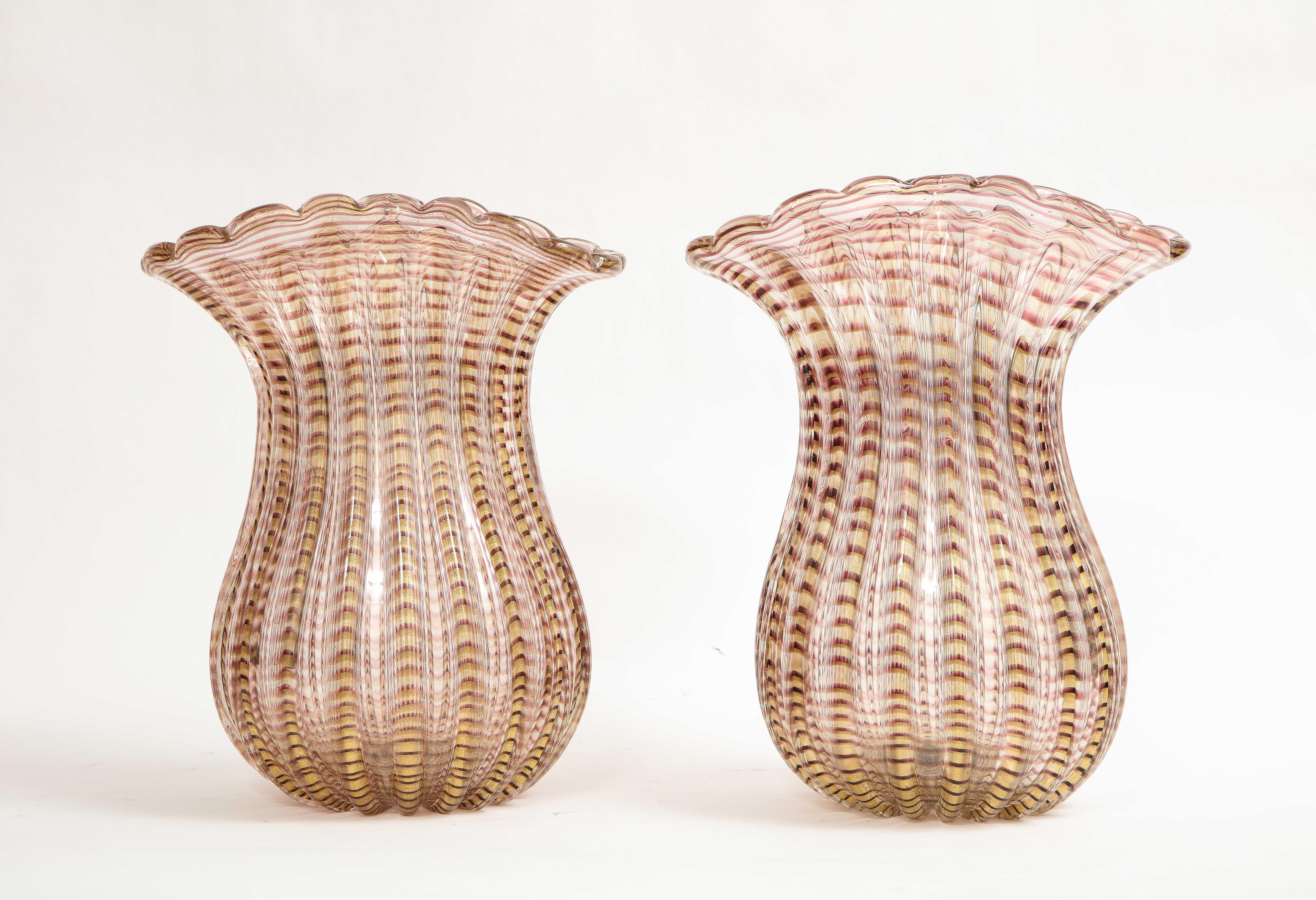 Paire de grands vases en verre soufflé strié, jaune et transparent de Murano, italiens et modernes du milieu du siècle.  Chacun d'entre eux est magnifiquement soufflé et découpé à la main pour former ces merveilleux vases qui sont superbes en termes