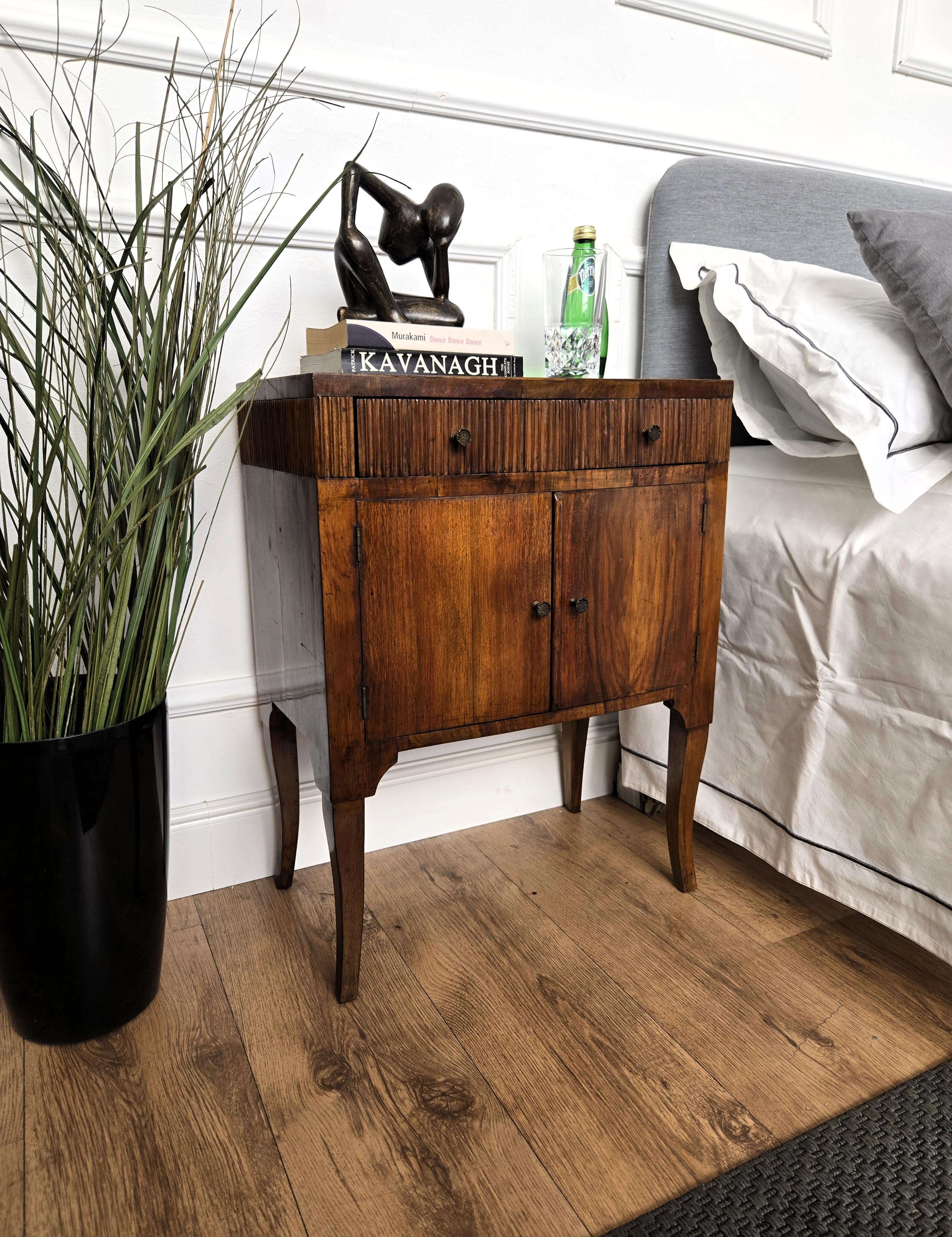 Très élégante et raffinée paire de tables de chevet italiennes des années 1950 Mid-Century Modern avec tiroir sculpté en biais et double porte complétée par des poignées en laiton. Ces pièces s'intègrent parfaitement à tous les styles de chambres à