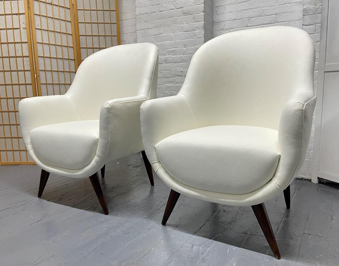 Pair of Italian style lounge chairs. Has solid wood splayed legs. Upholstered in an off-white fabric. Ico Parisi style.
  