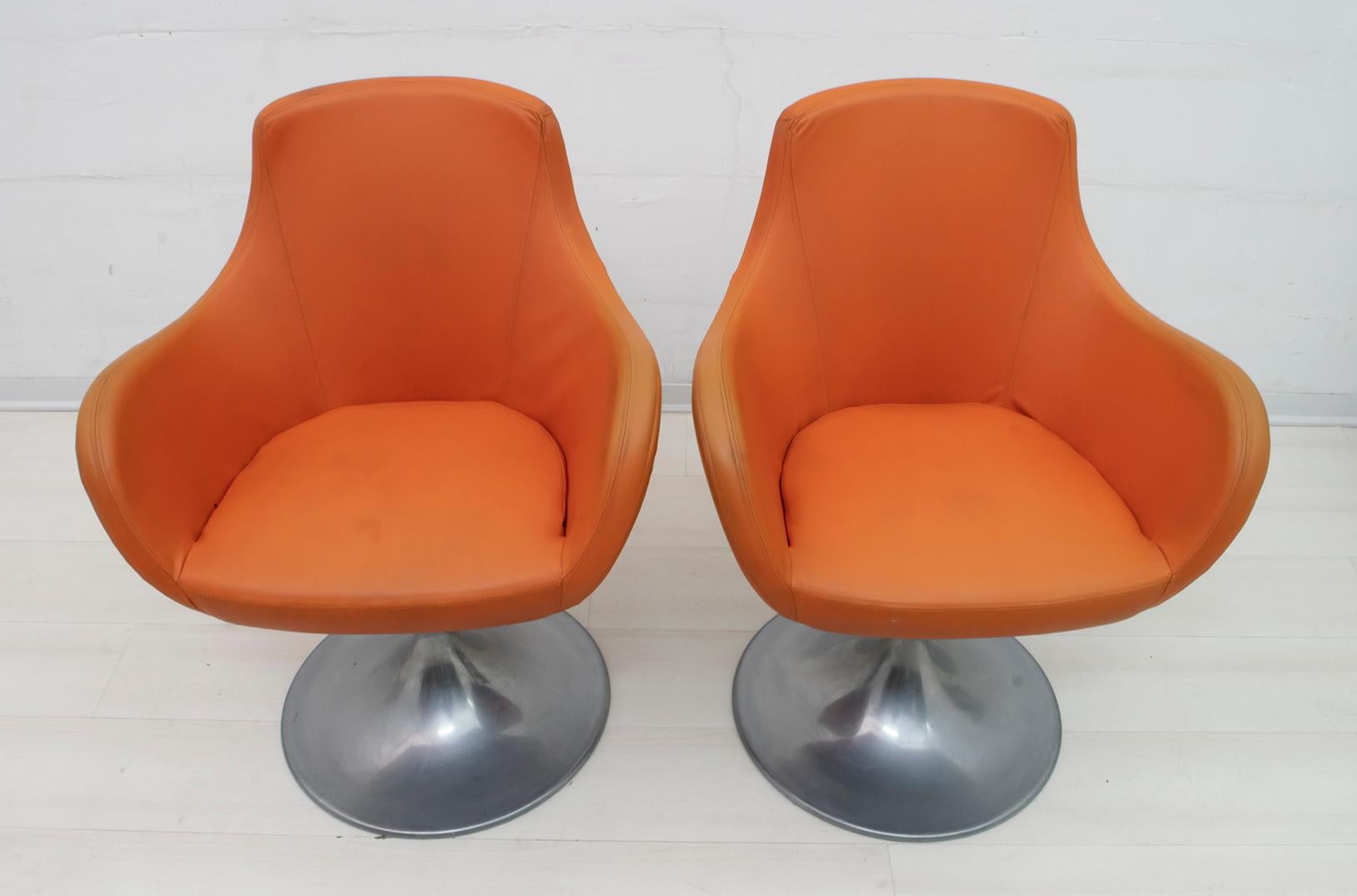 This pair of armchairs, typical Italian design of the 1960s, is upholstered in eco-leather and the swivel base is in aluminum.