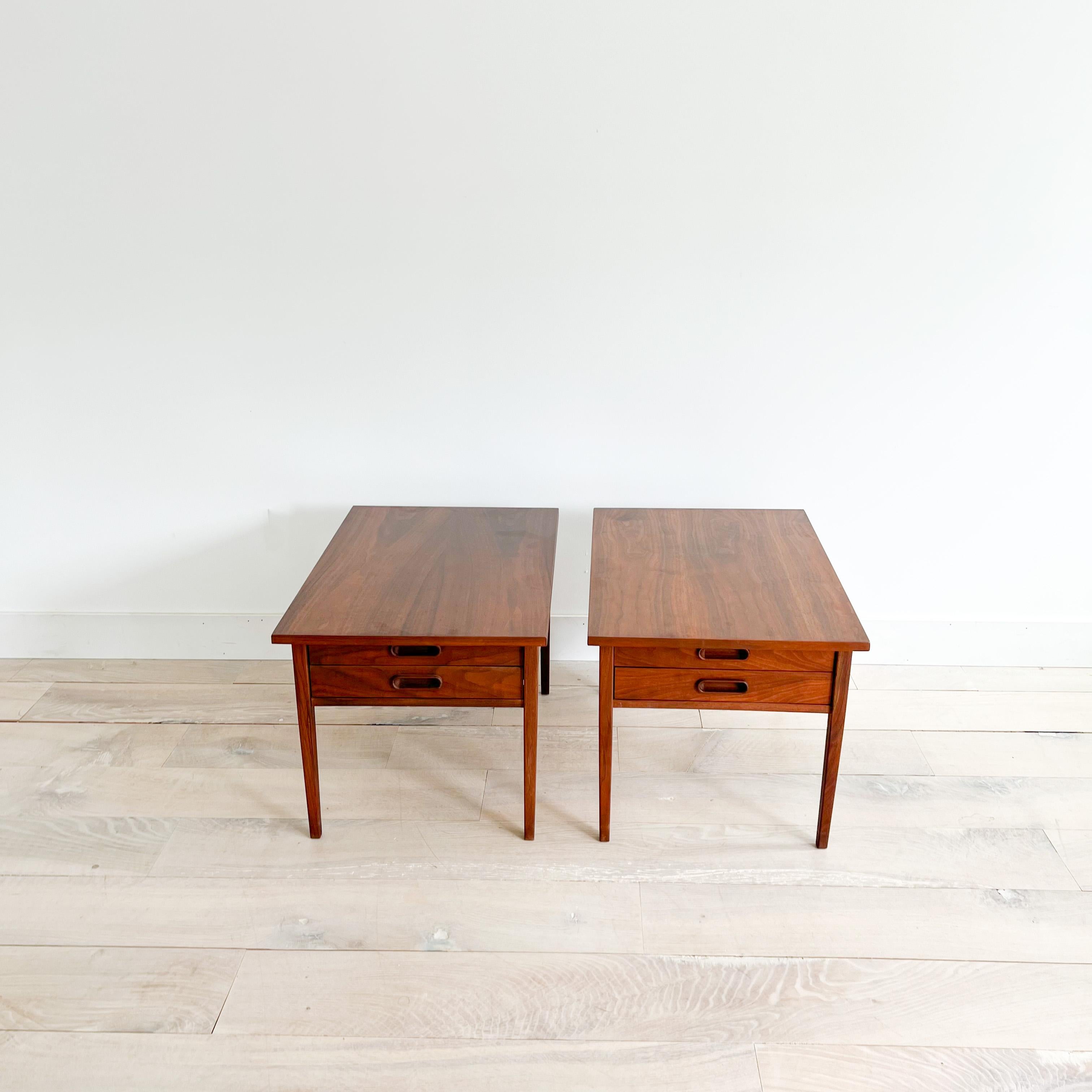 Pair of Mid-Century Modern walnut end tables by Jack Cartwright for Founders. The tops have been sanded and restored. Some light scuffing/scratching from age appropriate wear. Each end table has two drawers.

21”x30” 20.25”H.