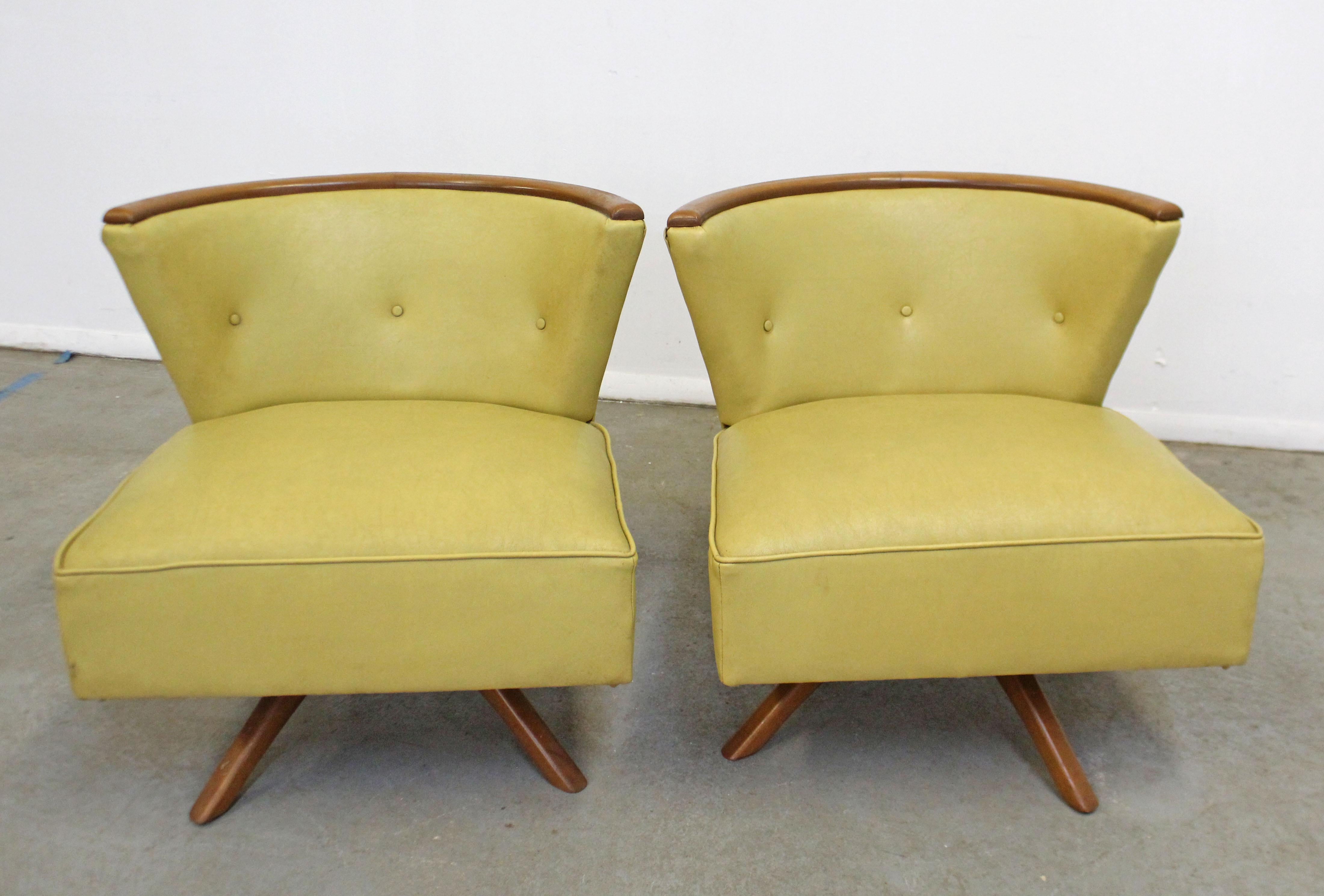 What a find. Offered is a pair of swivel slipper chairs attributed to Kroehler Smartset. They have vinyl upholstery and wooden bases, swivel mechanism is in working order. They are in structurally sound condition showing age wear (stains on