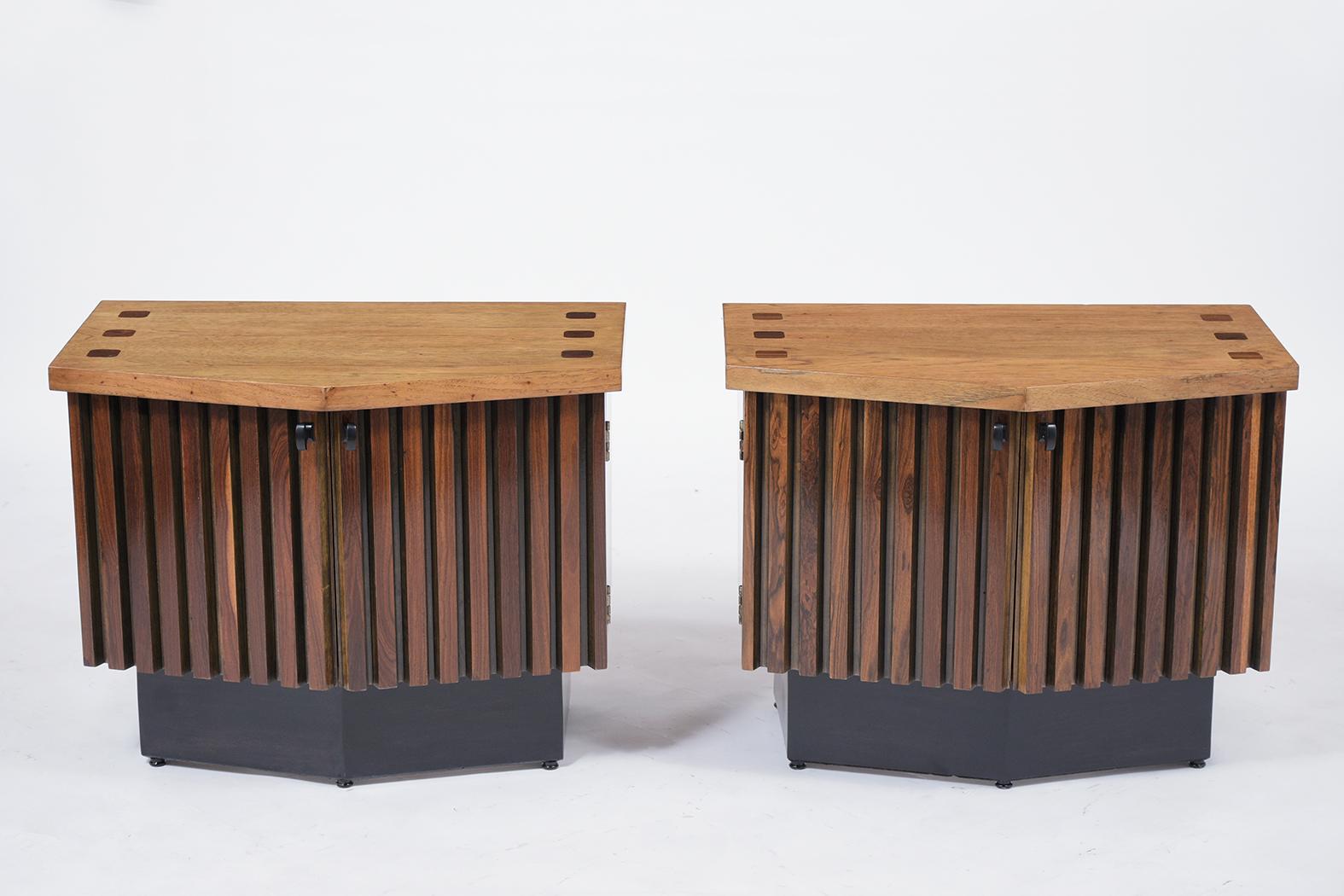 A sleek pair of midcentury nightstands that are made out of rosewood and mahogany that is newly stained in walnut and ebonize color combination and lacquered finish. They feature a flat top with a double door center, and the interior has plenty of