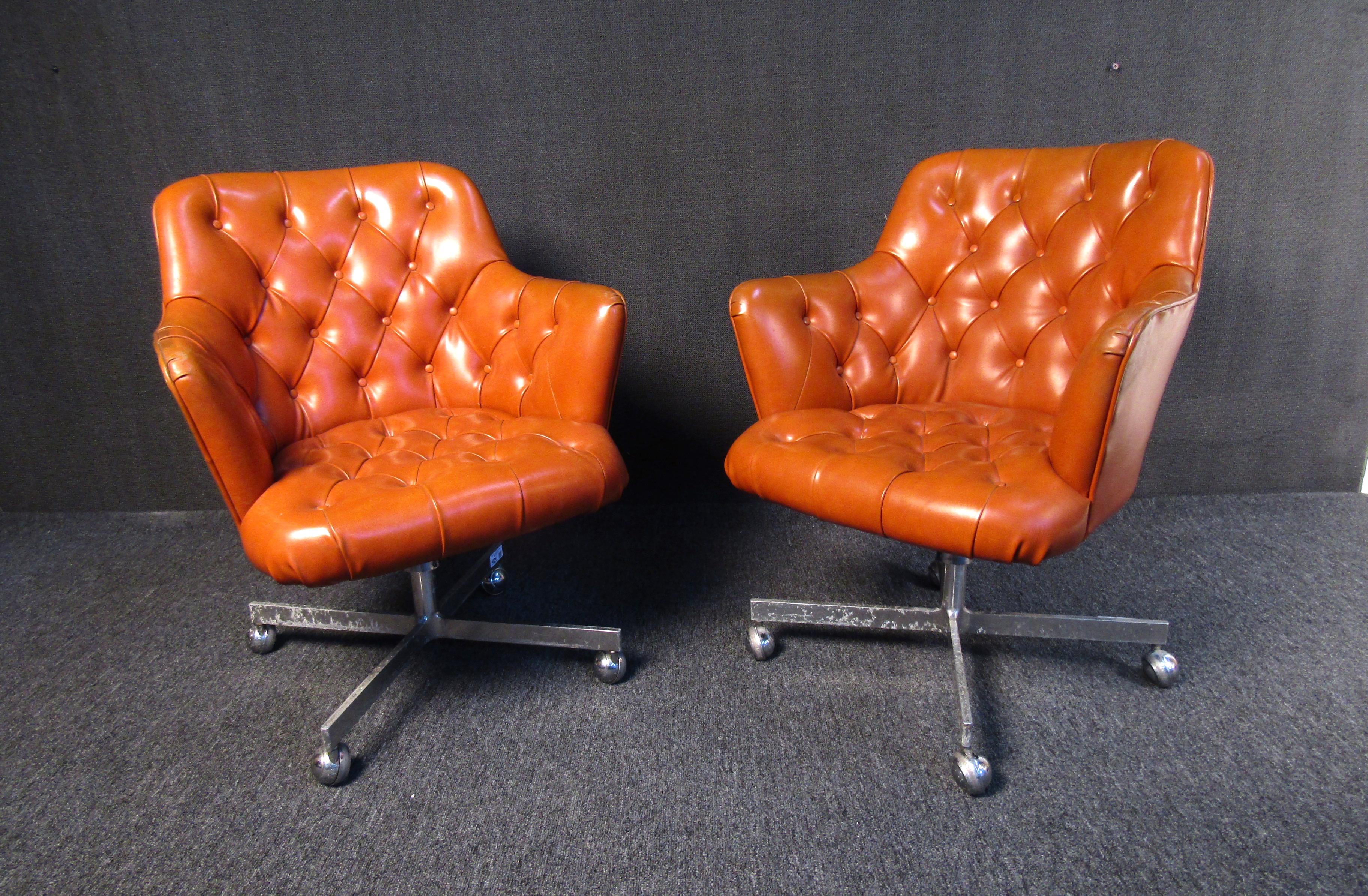 This impressive pair of Danish Mid-Century Modern armchairs is a bold and stylish addition to any interior. Plush leather padding and armrests make these chairs comfortable and easy to clean, while their orange color is sure to brighten up a room or