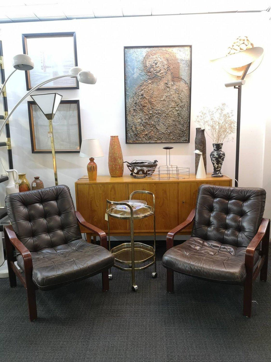 Small size brown leather armchairs from the 1970's. The leather upholstery aged very nicely, there are no tears, only slightly scarred. These chairs are super comfortable.