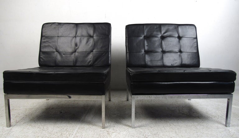 This stunning pair of vintage modern lounge chairs boast heavy chrome frames and tufted leather upholstery. The angled back legs and overstuffed seating add to the allure. A sleek and comfortable slipper design that looks great in any interior.
