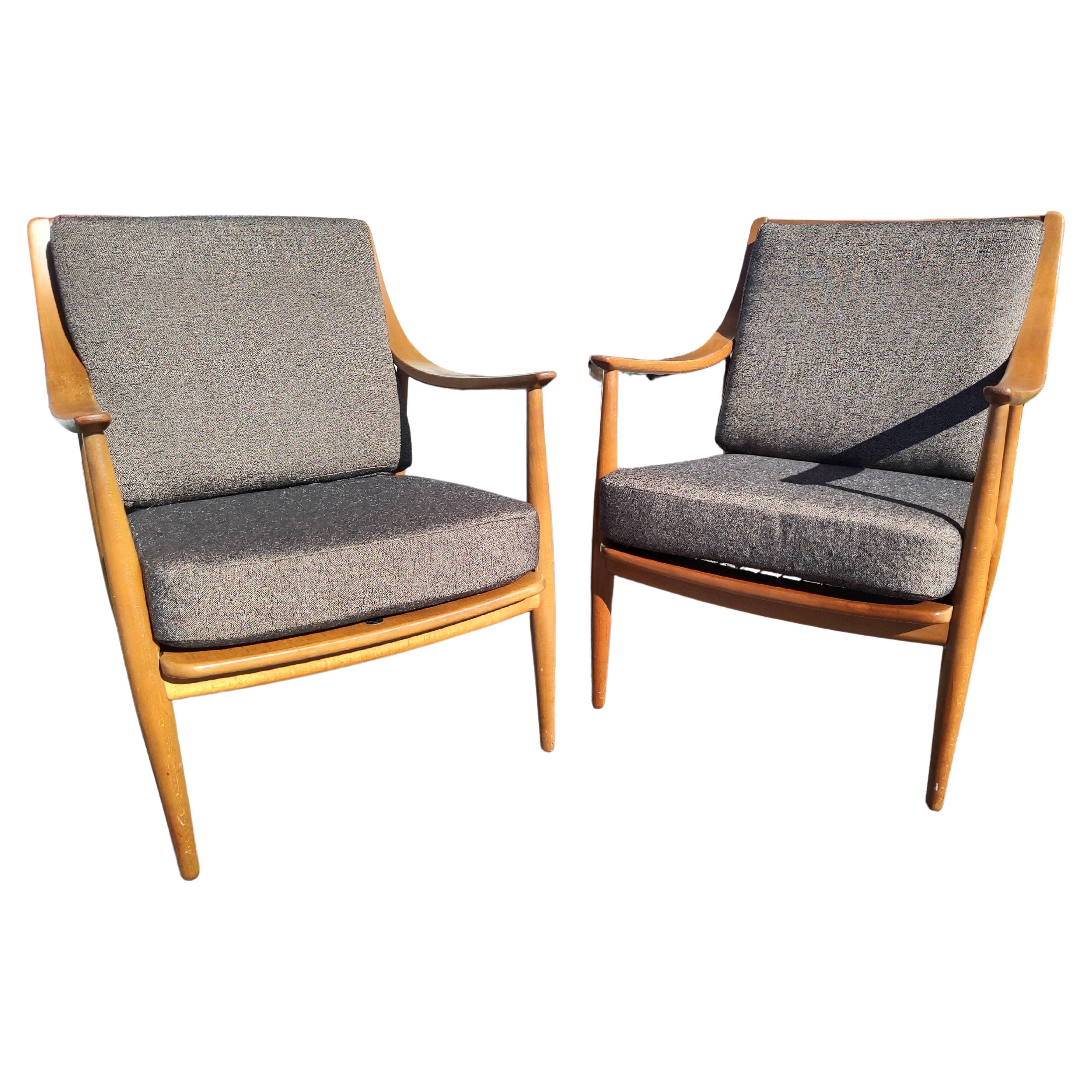 Schönes Paar skandinavischer skulpturaler Mid-Century Modern Stühle von Peter Hvidt und Olga Molgaard Neilson für John Stuart Inc. Hergestellt aus Nussbaumholz mit schräg gebogenen Armen und Spindelrücken. Brandneue Polsterung sorgt für ein tolles