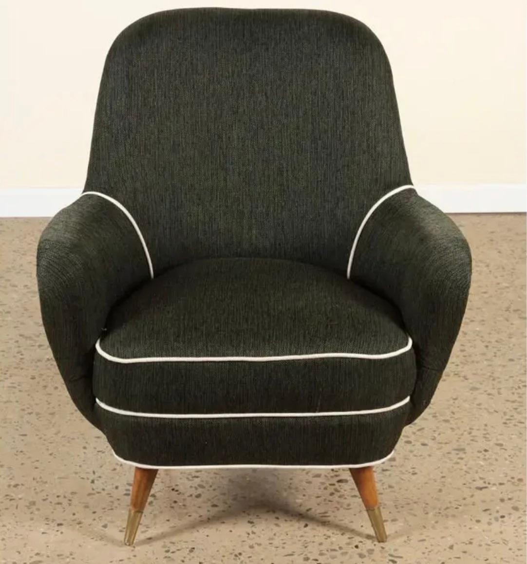 A pair of mid-century modern upholstered lounge chairs having brass trimmed splayed mahogany legs circa 1960. 