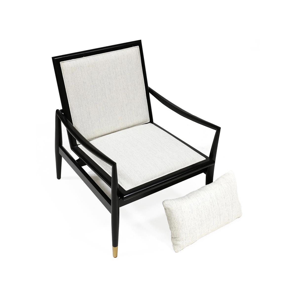 In an ebonized black lacquered finish. With an upholstered cushion backrest and seat in a Linen performance fabric. 

The classic modern and graceful frame with an angled back and swooping arms, with brass caps to the legs.

Dimensions: 26
