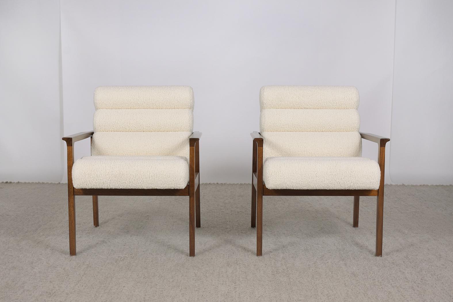 An extraordinary pair of modern armchairs hand-crafted out of walnut in great condition and newly restored by our professional craftsmen team. These fabulous lounge chairs feature a sleek walnut frame beautifully stained rich walnut color with a