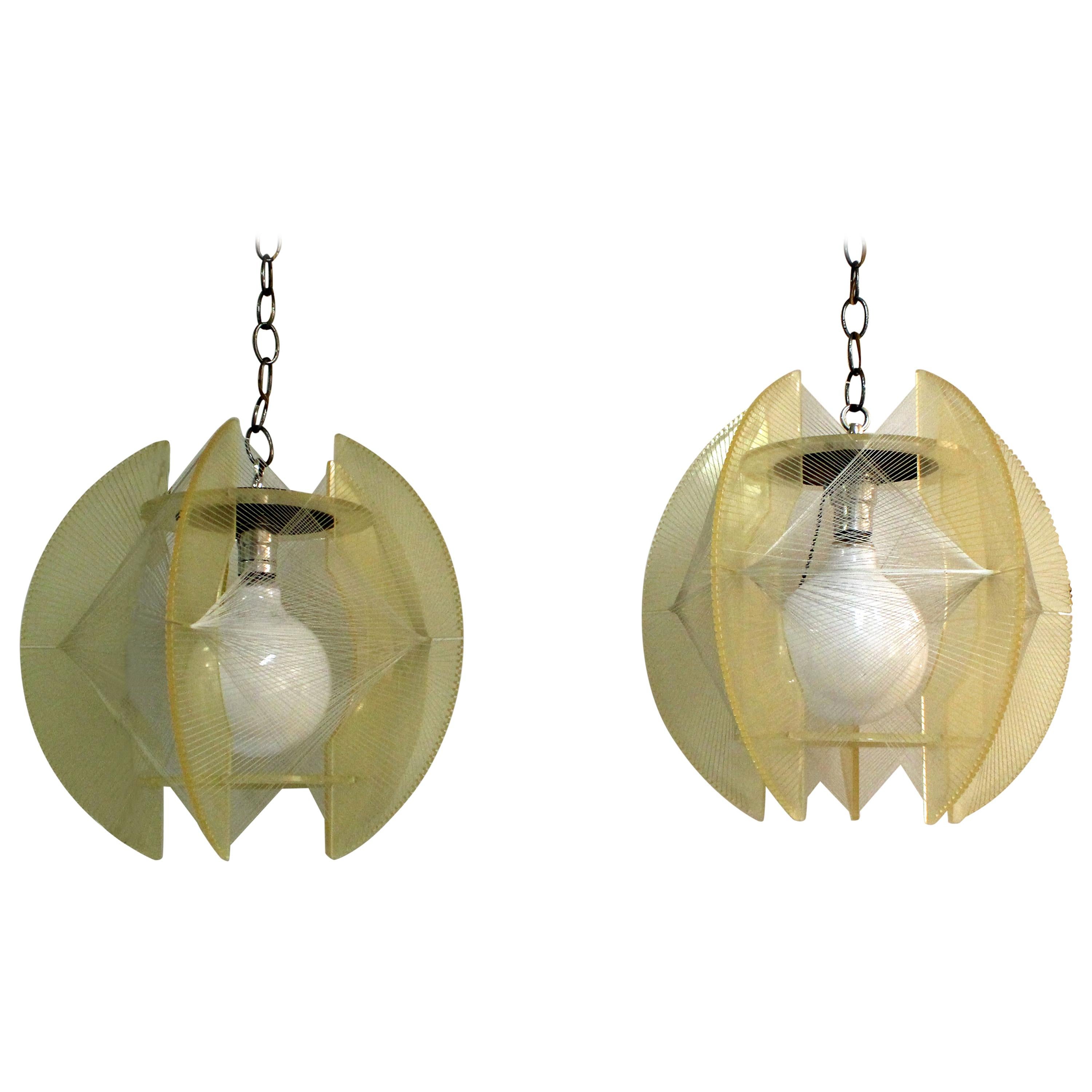 Offered is a retro pair of Mid-Century Modern pendant lights. These hanging lamps are made with Lucite and nylon string. They are in good, working condition, showing slight wear from age. They are not signed.

Dimensions:
14