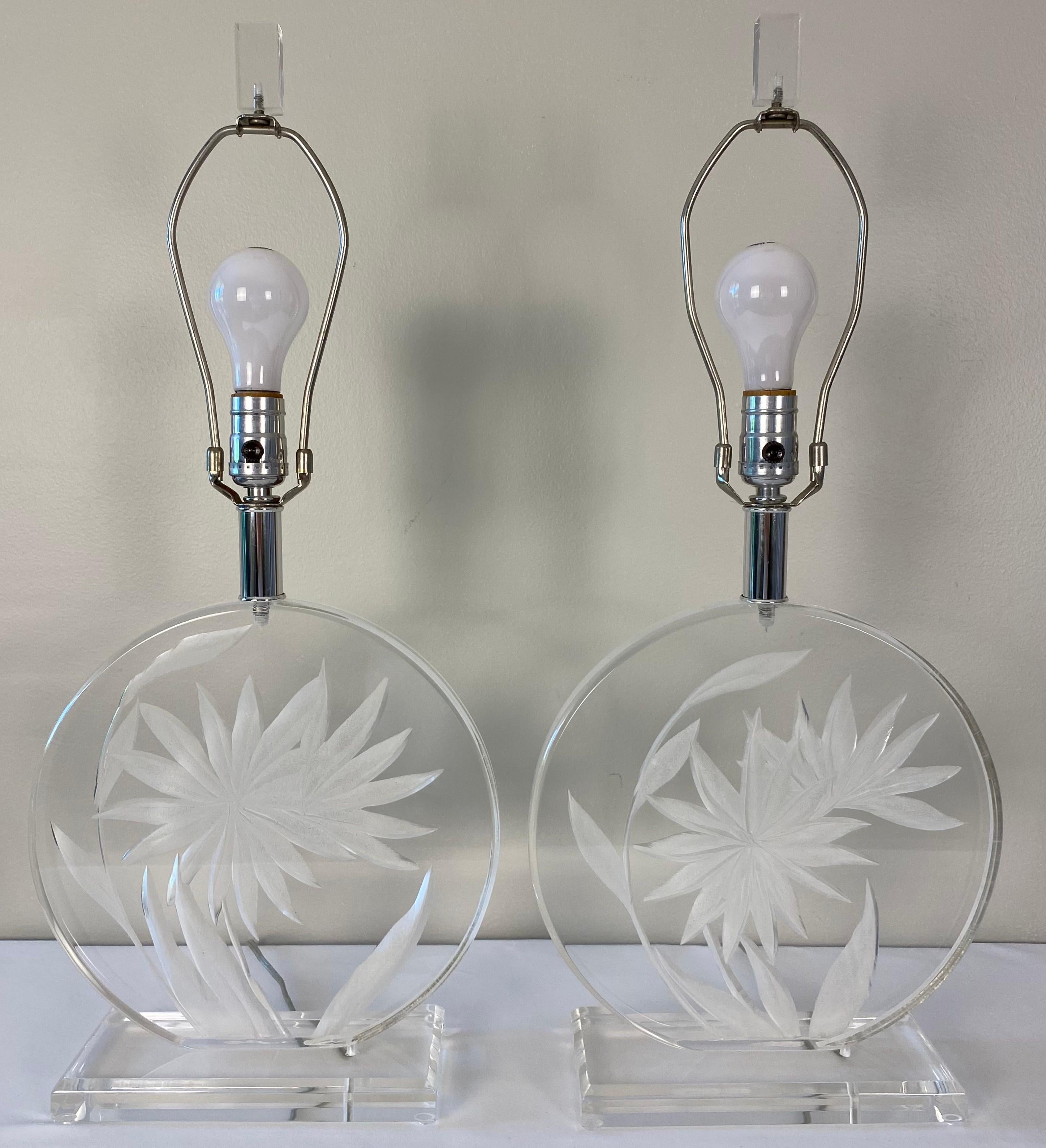 A very good quality pair of lucite table lamps attributed to Karl Springer. This stylish pair of lucite table lamps have an etched floral and leaf design making them more interesting and a perfect pair to display on your end tables, nightstands or