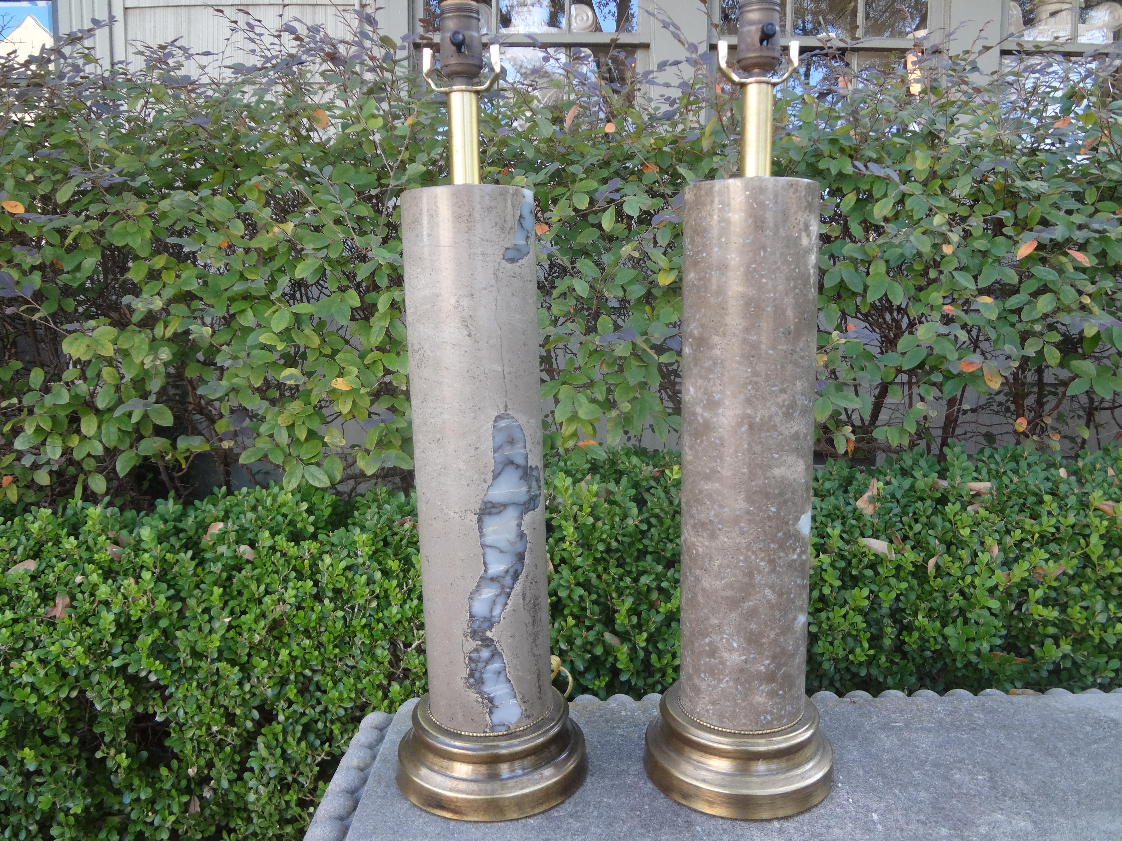 Gorgeous tall pair of cylindrical modernist marble table lamps, possibly Italian. The unusual marble on each column lamp is unique yet this is a pair. This versatile pair of Hollywood Regency lamps have been newly wired for the U.S. market and would