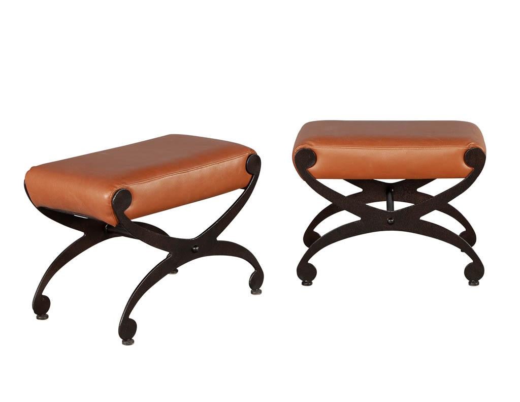 Pair of Mid-Century Modern metal benches. Dark hammered metal curved x-shaped bases with thick upholstered seats in a dark saddle leather tone. Original, USA, circa 1970s. Leather has fading on tops consistent with age and use. Please review the