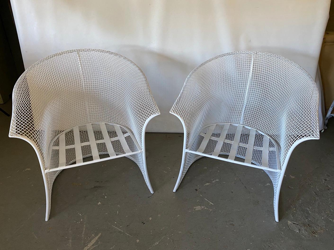 Pair of wonderfully stylish Russell Woodard style mesh wire arm chairs with rounded barrel back and arms. Metal mesh body rests on wrought iron legs. Suitable for indoor, outdoor, garden, patio or porch use.