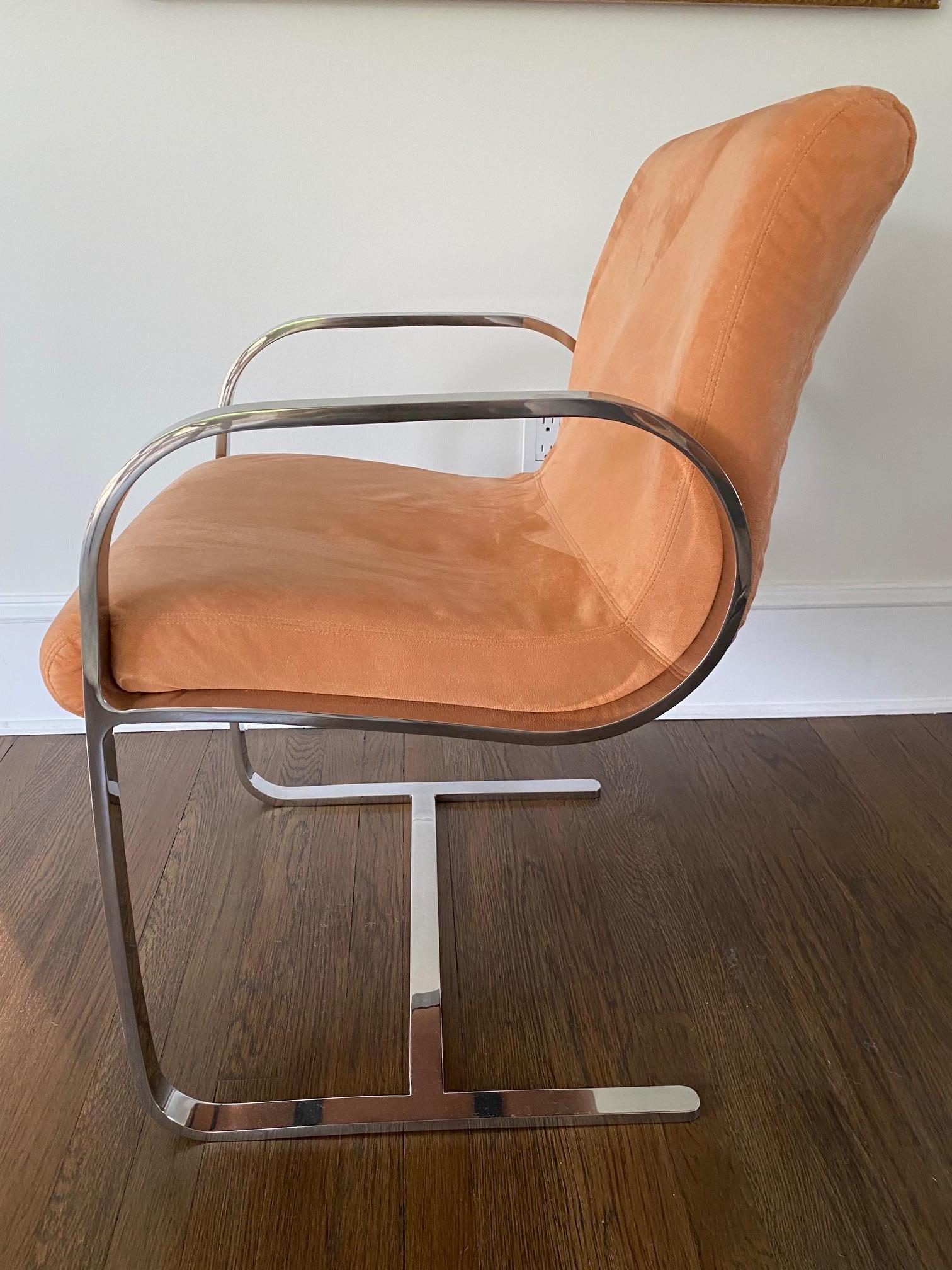 Cool pair of mid century modern Milo Baughman style arm chairs having chrome arms and bases and salmon colored smooth ultrasuede upholstery.

Arm height 25