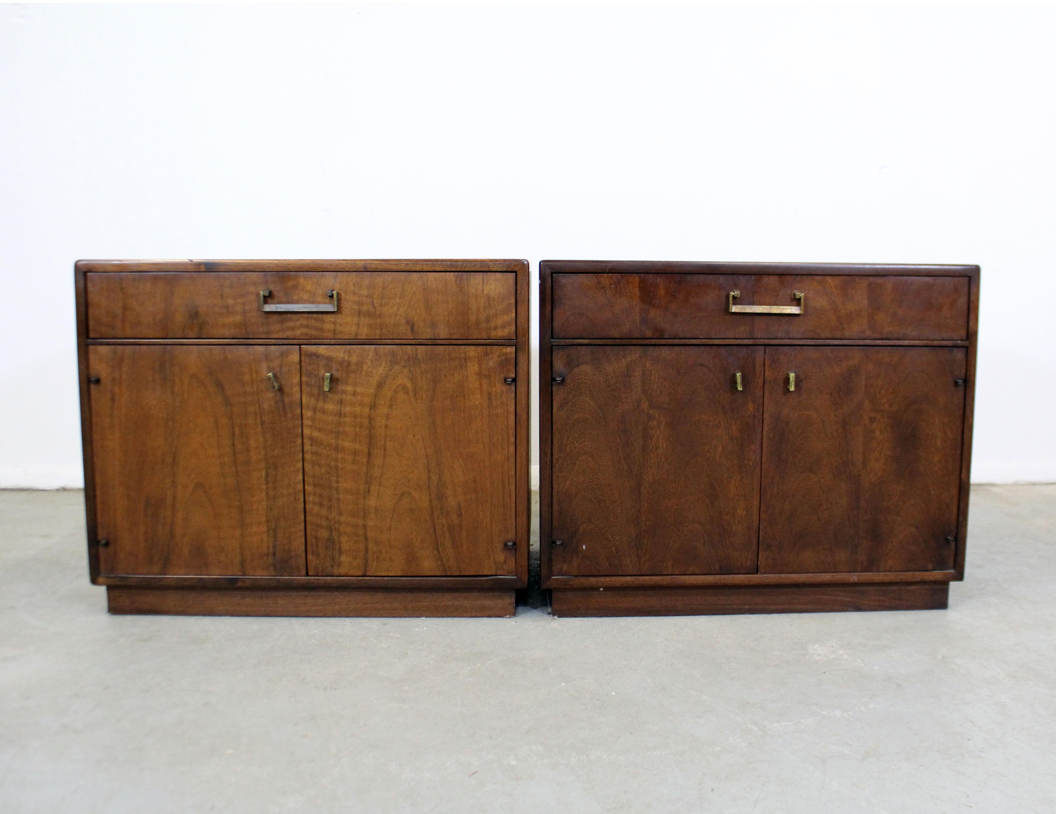 Offered is a pair of Mid-Century Modern nightstands, attributed to Milo Baughman, by founders. They are made of walnut with burl wood-faces and brass pulls. Features 1 single drawer and 2 doors with inner storage. They are in great condition, show