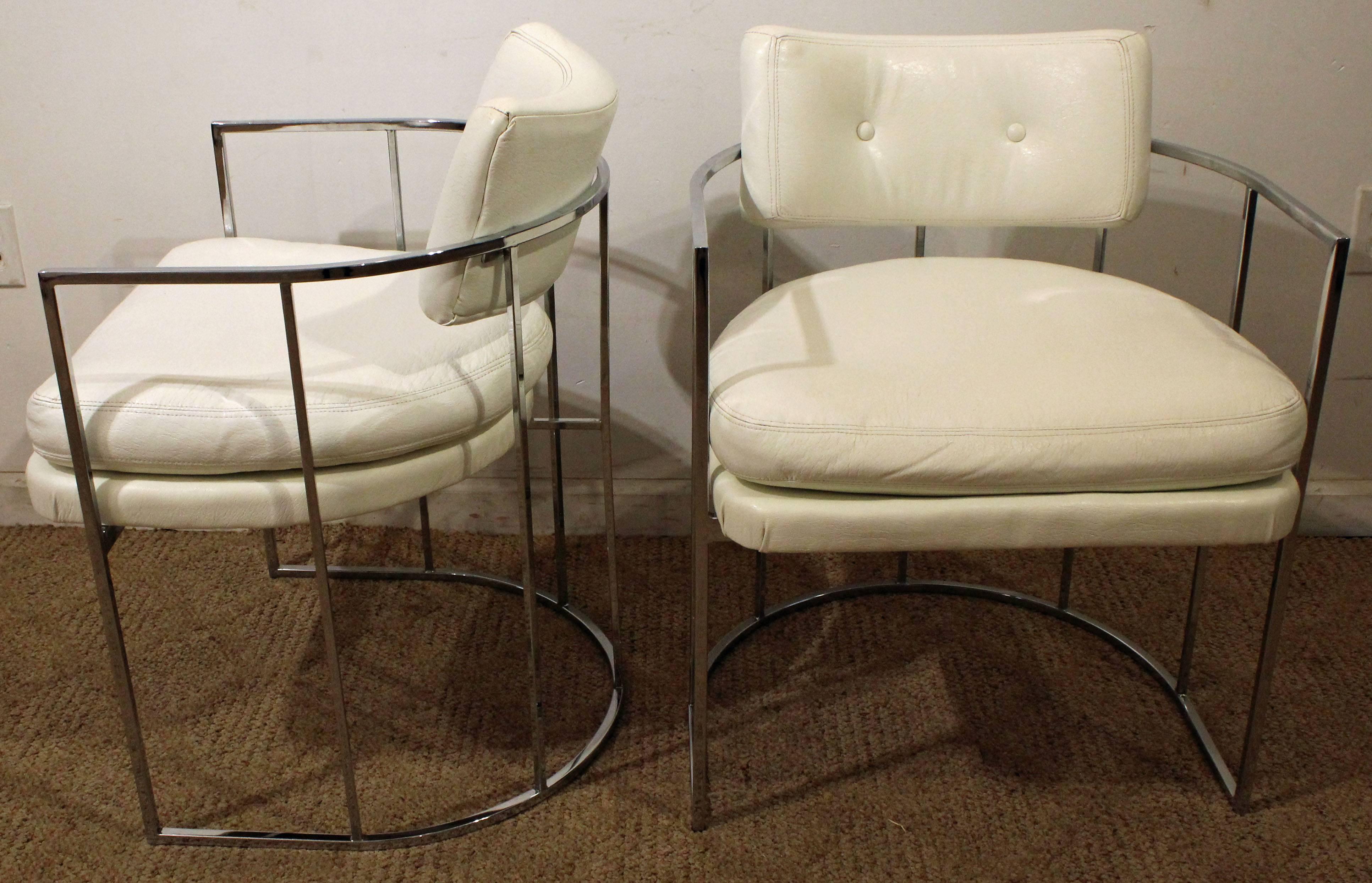 These chairs feature white vinyl upholstery and barrel-back chrome bases. They are signed by Thayer Coggin.

Measure: 22