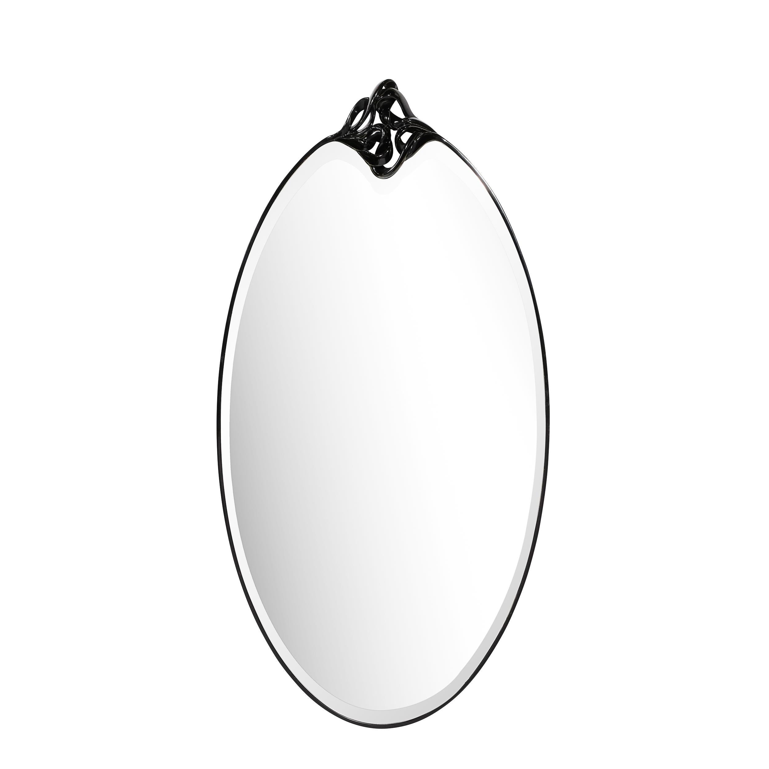 This stunning pair of Mid-Century Modern wall mirrors were realized in the United States during the latter half of the 20th Century. They feature ovoid shapes with clear mirror centers wrapped in lustrous black resin. Crowning the top of each are