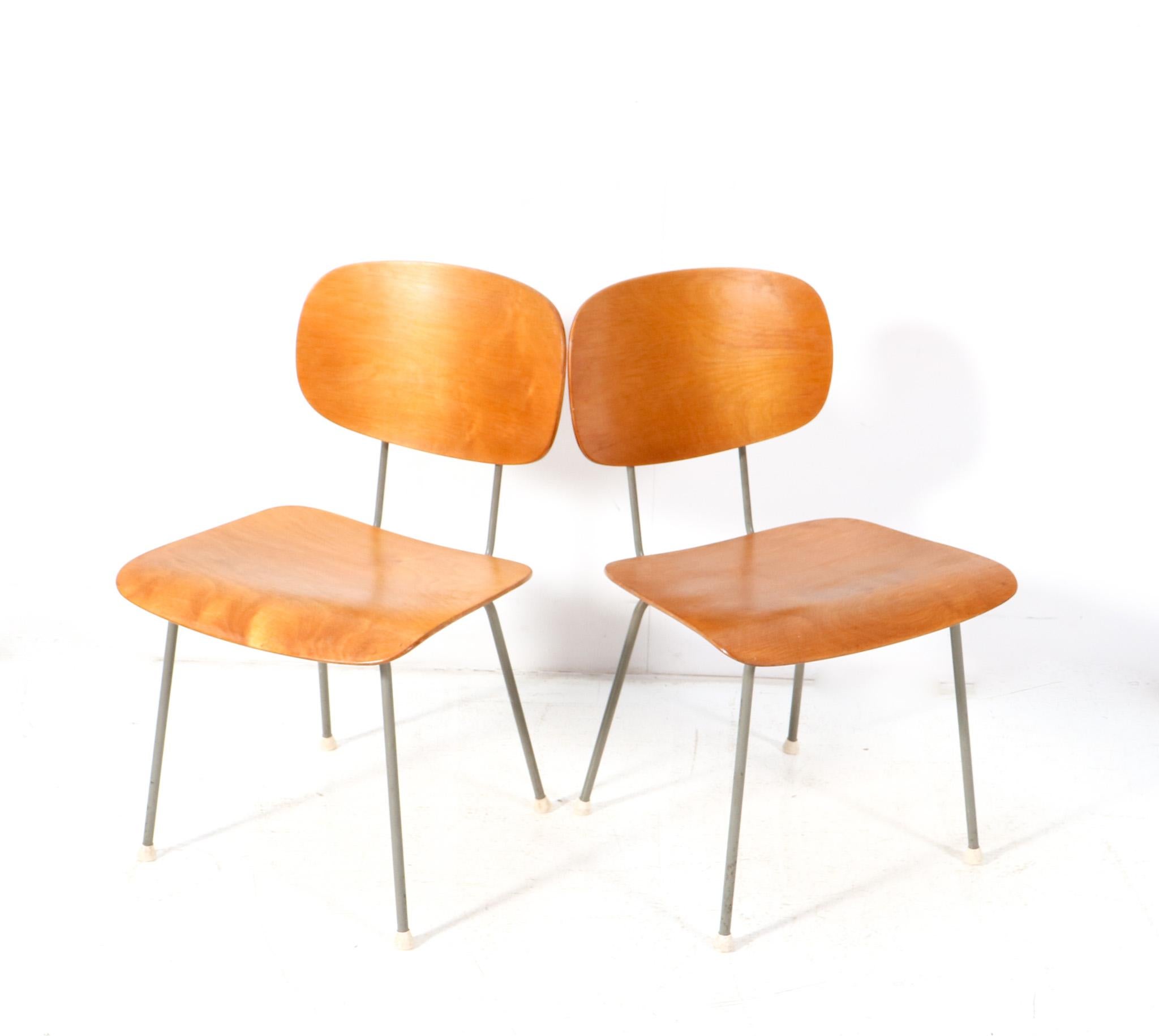 Stunning and elegant pair of Mid-Century Modern side chairs.
Design by Wim Rietveld for Gispen.
Original grey lacquered metal frames with original plywood backs and seats.
Marked underneath the seats with the original manufacturers stamp.
This