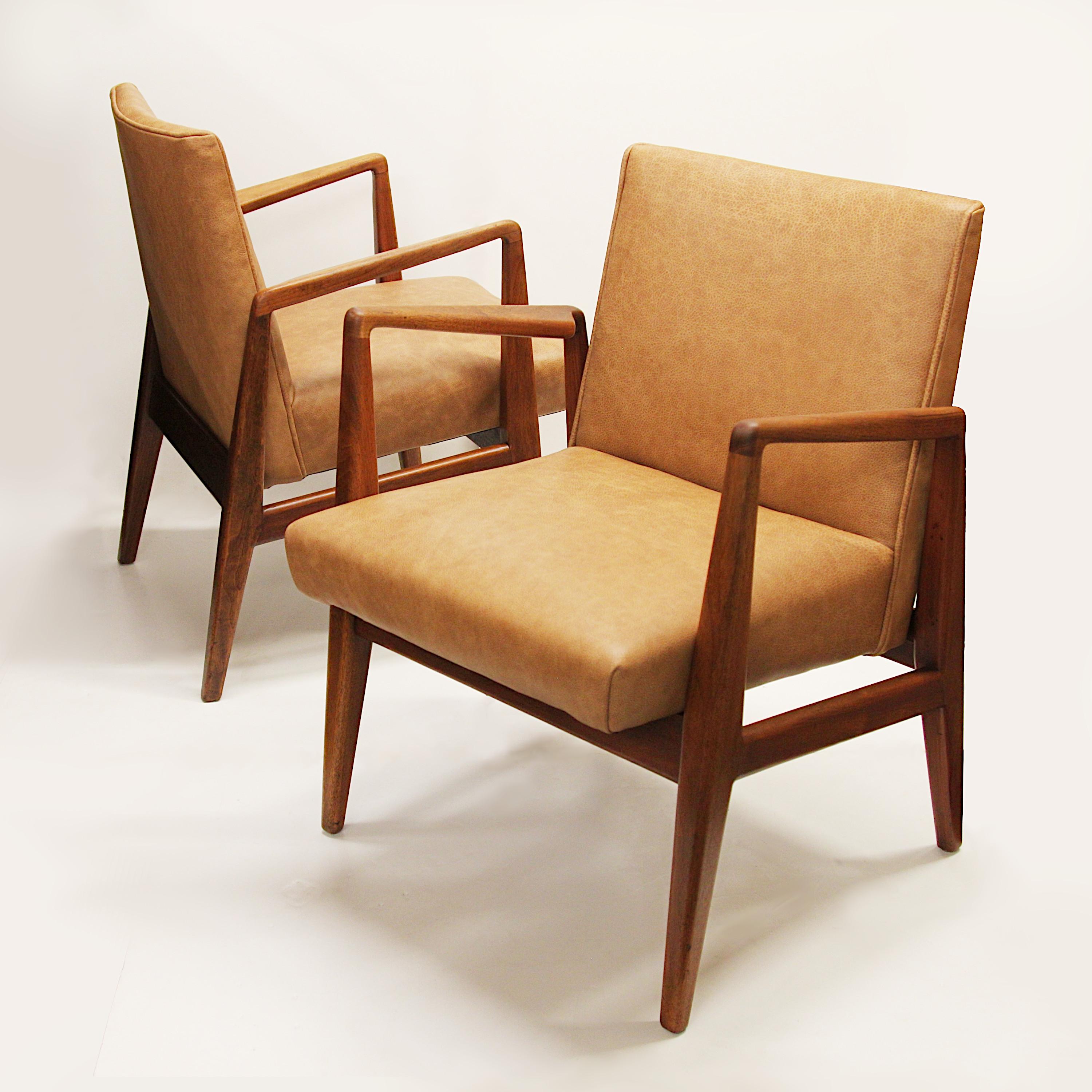 Fantastic pair of Model C-120 armchairs chairs designed by Jens Risom and manufactured by Jens Risom Design Inc. Chairs feature beautifully sculpted walnut frames and are newly upholstered in a bold gold/light brown leather. These are great examples