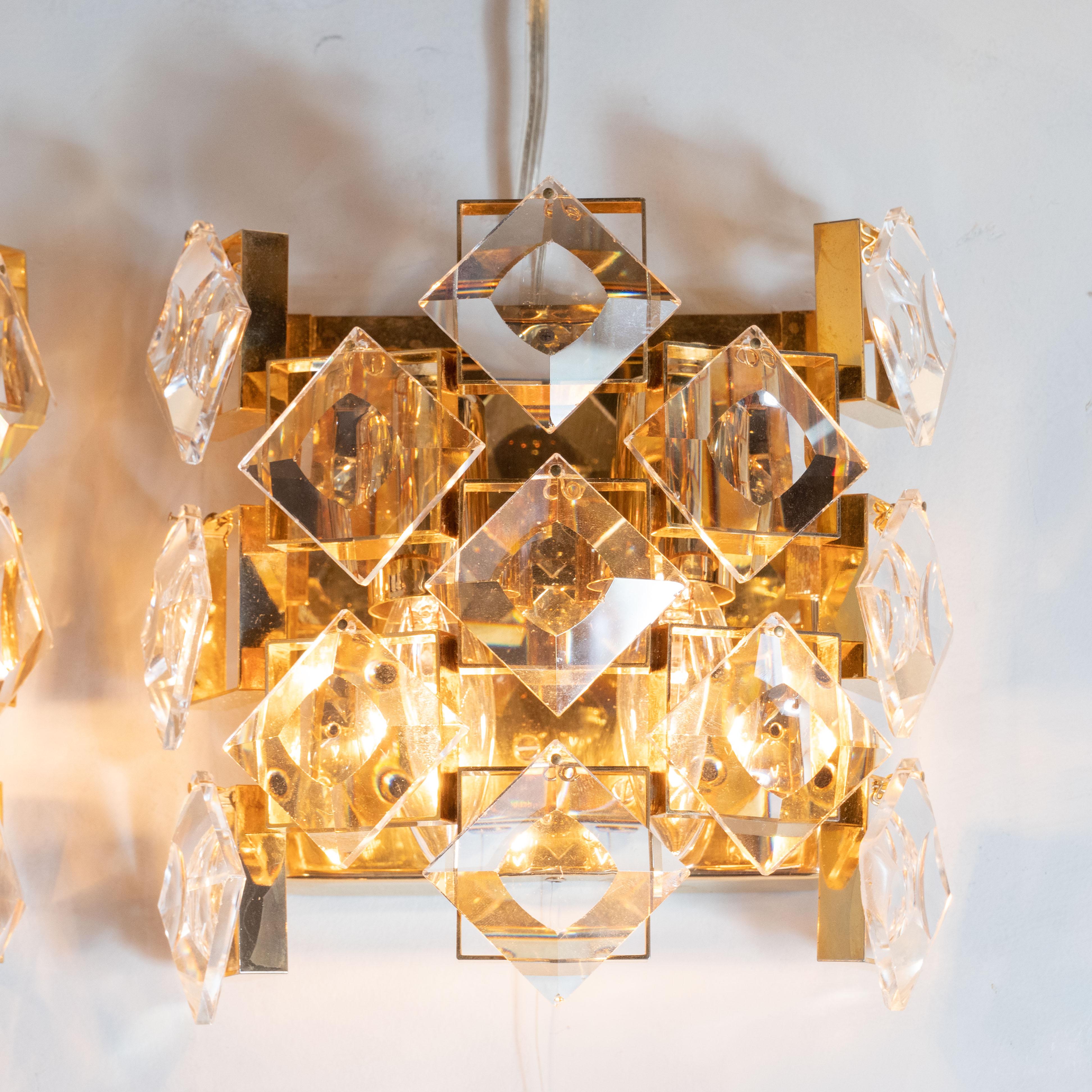 This glamorous pair of sconces were realized in Austria, circa 1960. They feature square polished brass frames with beveled translucent diamond form crystals creating mosaic walls on the three exposed sides. These sconces are like little jewels,