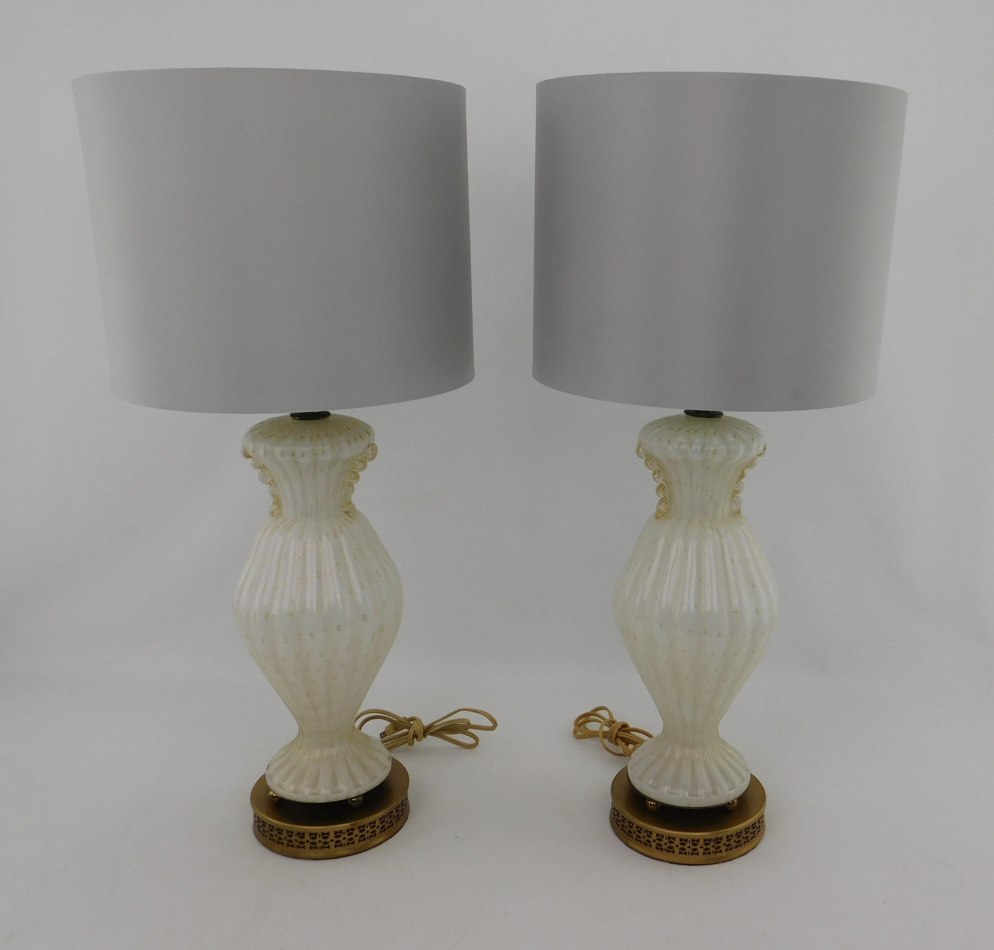 Cette paire de lampes de table en verre d'art moderne du milieu du siècle dernier est faite de verre soufflé à la main avec des mouchetures dorées. Cette lampe a été fabriquée à Murano, en Italie, vers 1960. Bases métalliques robustes avec une