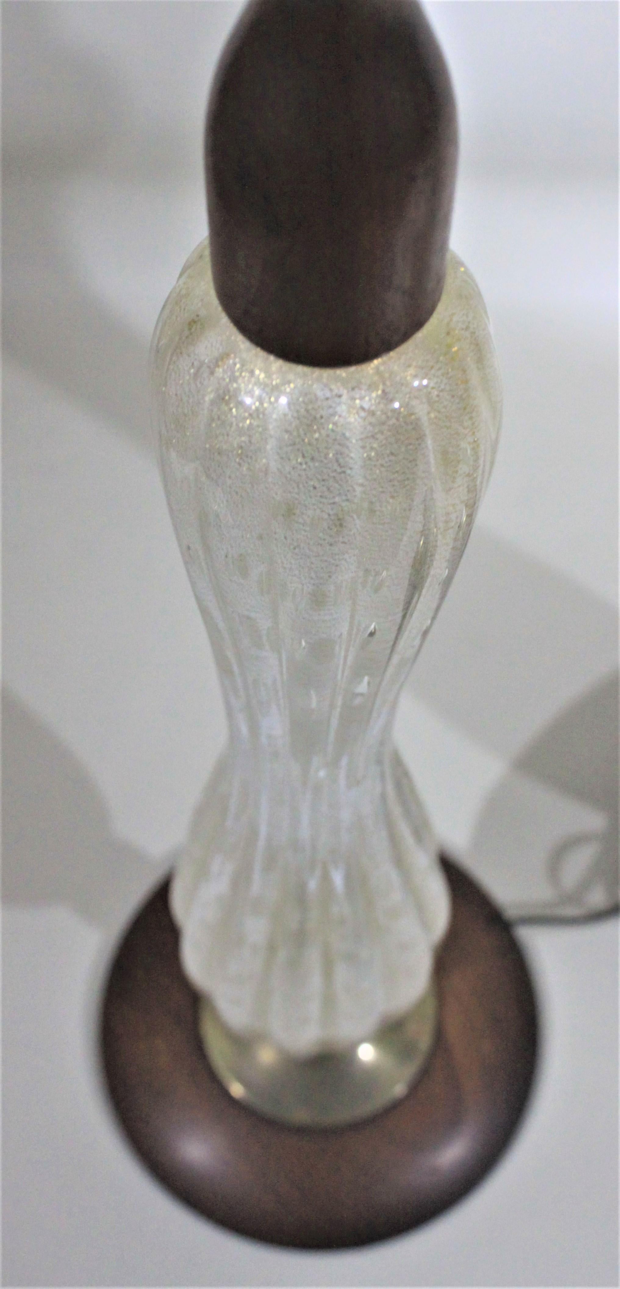 Cette paire de lampes de table modernes du milieu du siècle a été produite à Murano, en Italie, dans le style de Barovier. Les lampes sont faites de verre d'art nervuré blanc et d'aventurine avec des accents de bois de teck sur le dessus et la base.