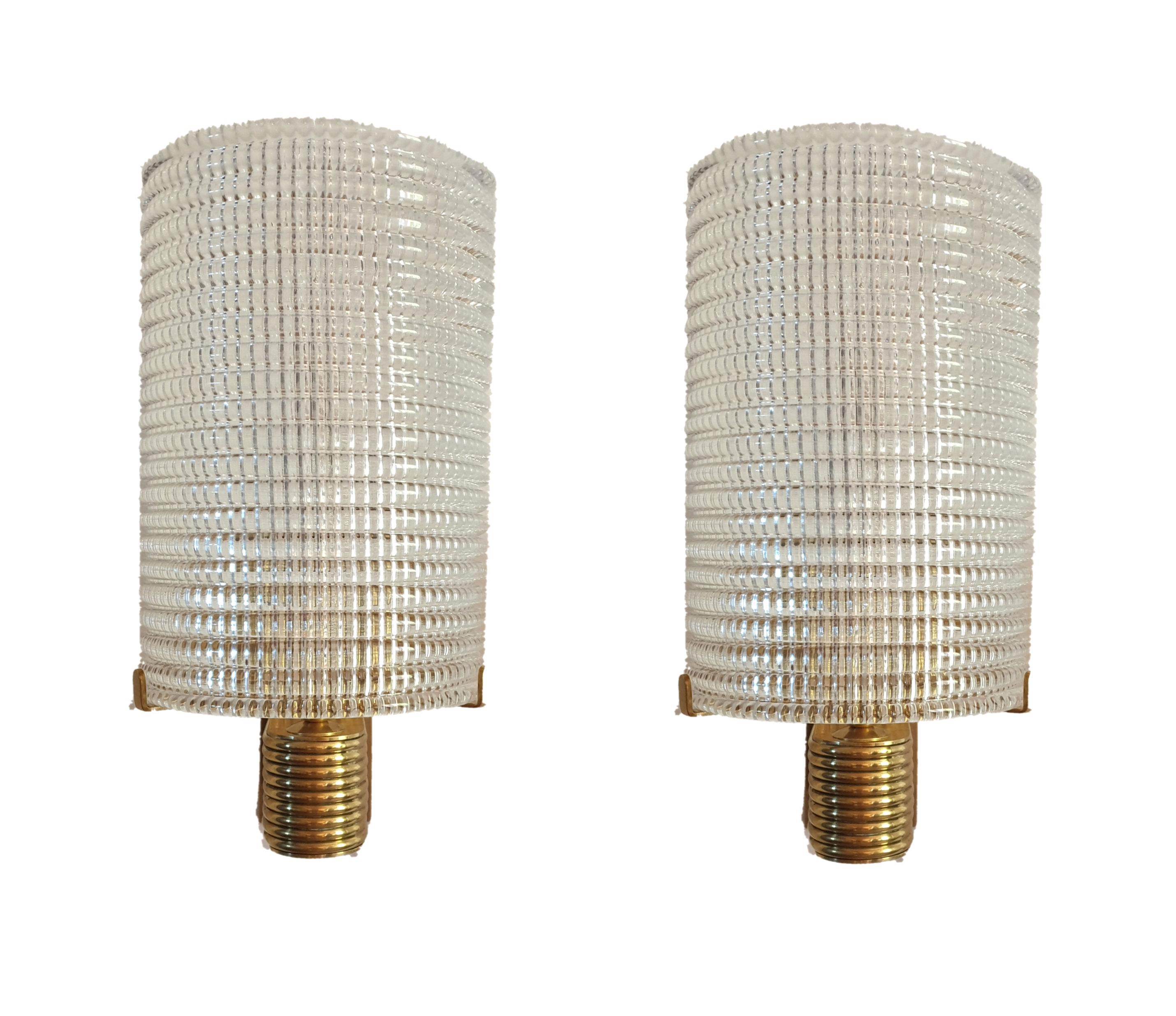 Pair of textured clear Murano glass and brass wall sconces, Mid-Century Modern, Italy, 1960s.
One light each, rewired.
Their design is simple and elegant.
Beautiful light when lit.
Excellent condition.
 