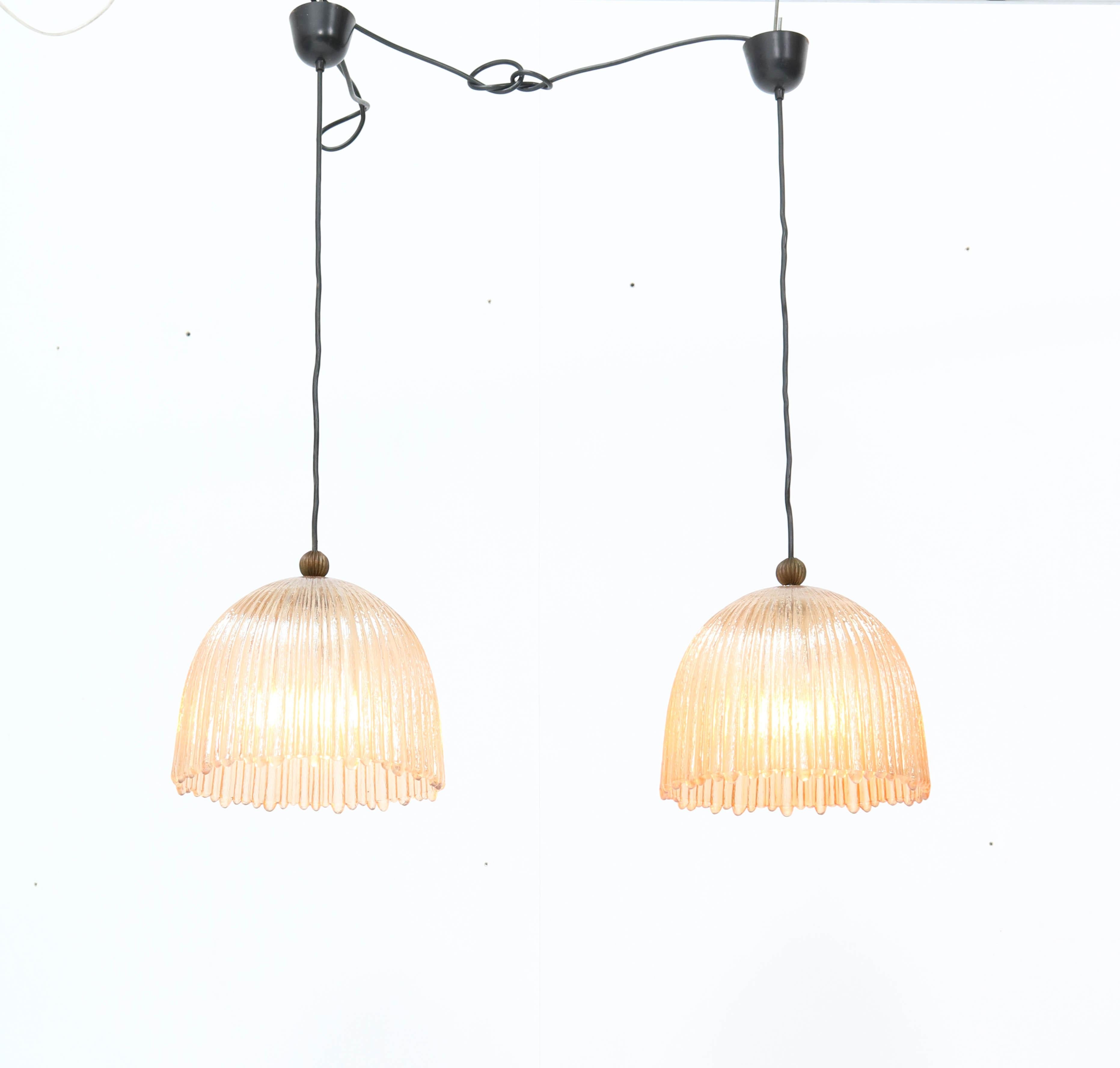 Stunning pair of Mid-Century Modern pendant lights.
Striking Italian design from the 1960s.
Original Murano shades.
Each pendant has one socket for a E-27 light bulb.
In good original condition with a beautiful patina.