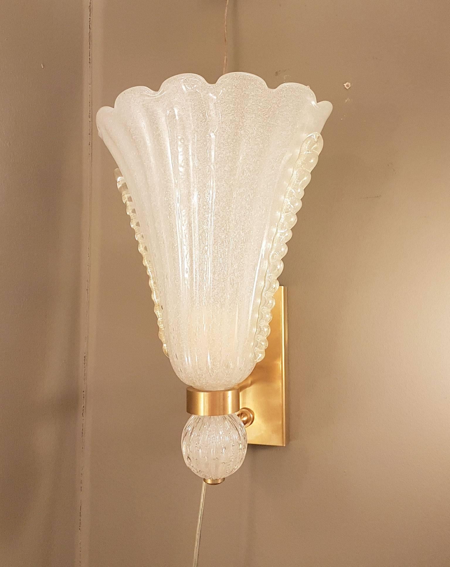 Pair of corolla shaped Murano glass Barovier e Toso sconces.
Italy, 1960s.
The Murano glass is Pulegoso, which means, that numerous irregular small air bubbles voluntarily make the glass translucent, with gold inclusions and brass mounts.
One