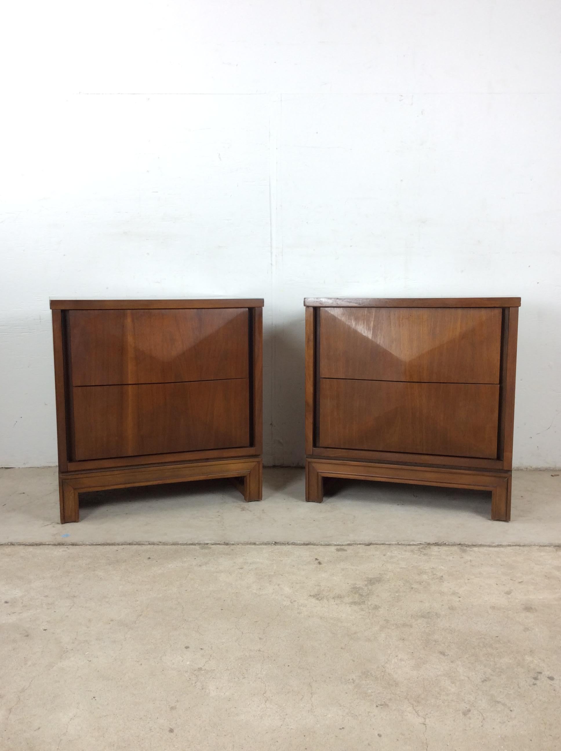 This pair of mid century modern nightstands by Johnson-Carper feature hardwood construction, beautiful walnut veneer with original finish, two dovetailed drawers with beveled front, unique sculpted legs and durable formica top.   Matching lowboy,