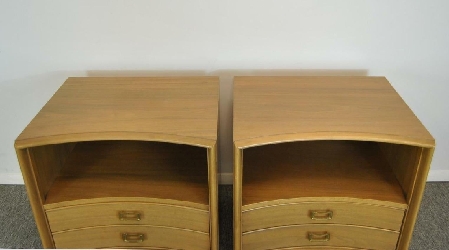 Classic clean midcentury design on this pair of nightstands designed by Paul Frankl for the Johnson Furniture Co of Grand Rapids, Michigan. Features include curved fronts, a magazine shelf and two dovetailed drawers with brass hardware. Stands are