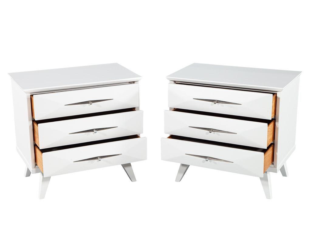 Expertly restored to their former glory in a sleek satin white lacquer finish. These nightstands are a testament to the timeless design aesthetic of the mid-century era, with their clean lines, minimalist silhouette, and functional design. Made in