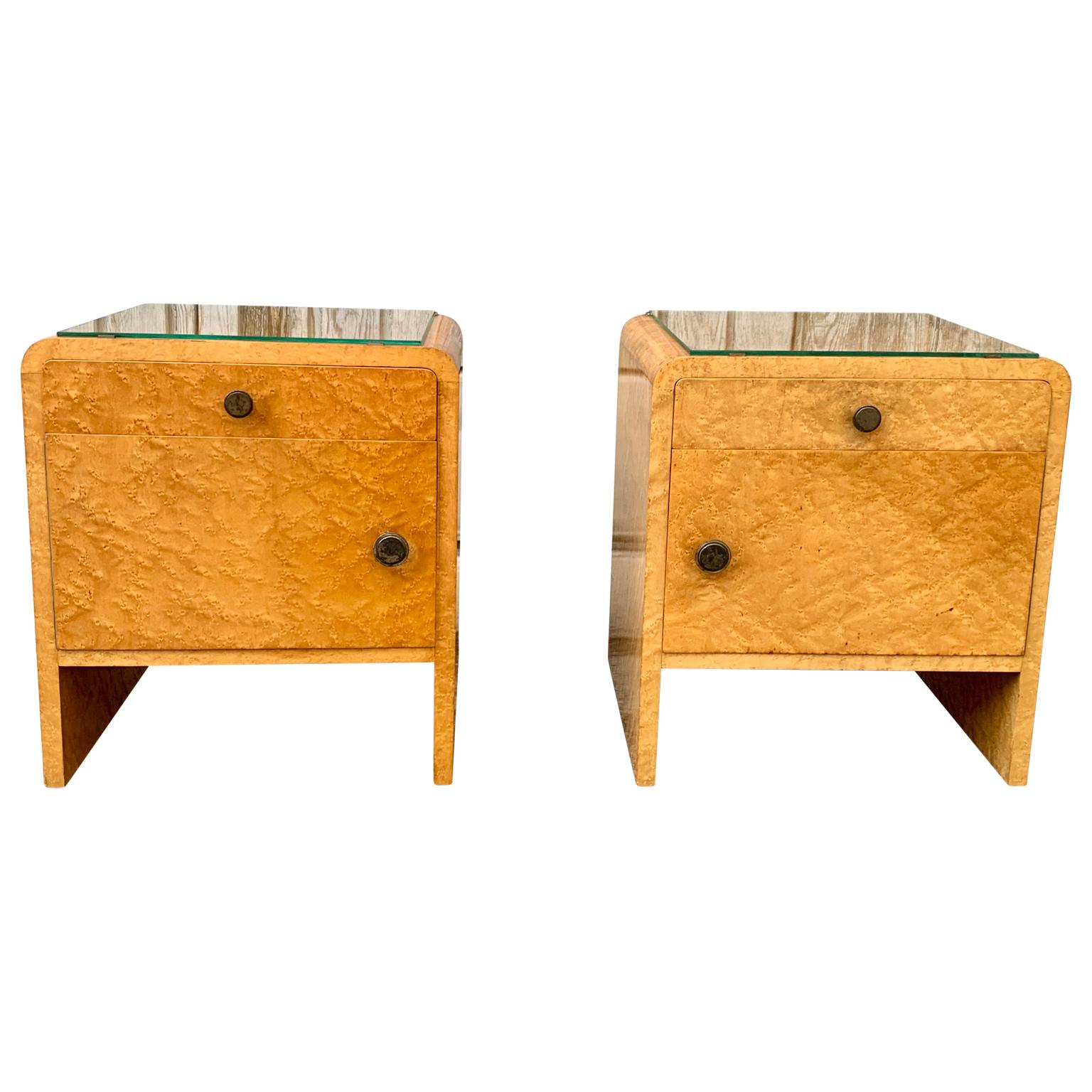 A charming pair of Swedish nightstands or small night tables in birch burl veneer wood with removable glass tops and the original brass hardware.
This set is a honest pair, meaning that the set has left and right facing doors the cabinets. Open and
