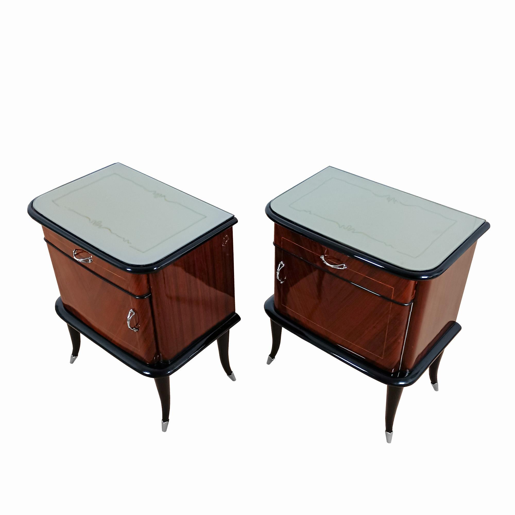 Pair of nightstands in blackened beech and rosewood veneer with lemon tree mouldings, nickel-plated brass handles and feet, and sapele interior. Silver glass top with gold trim. French polished.

Italy c. 1940

 